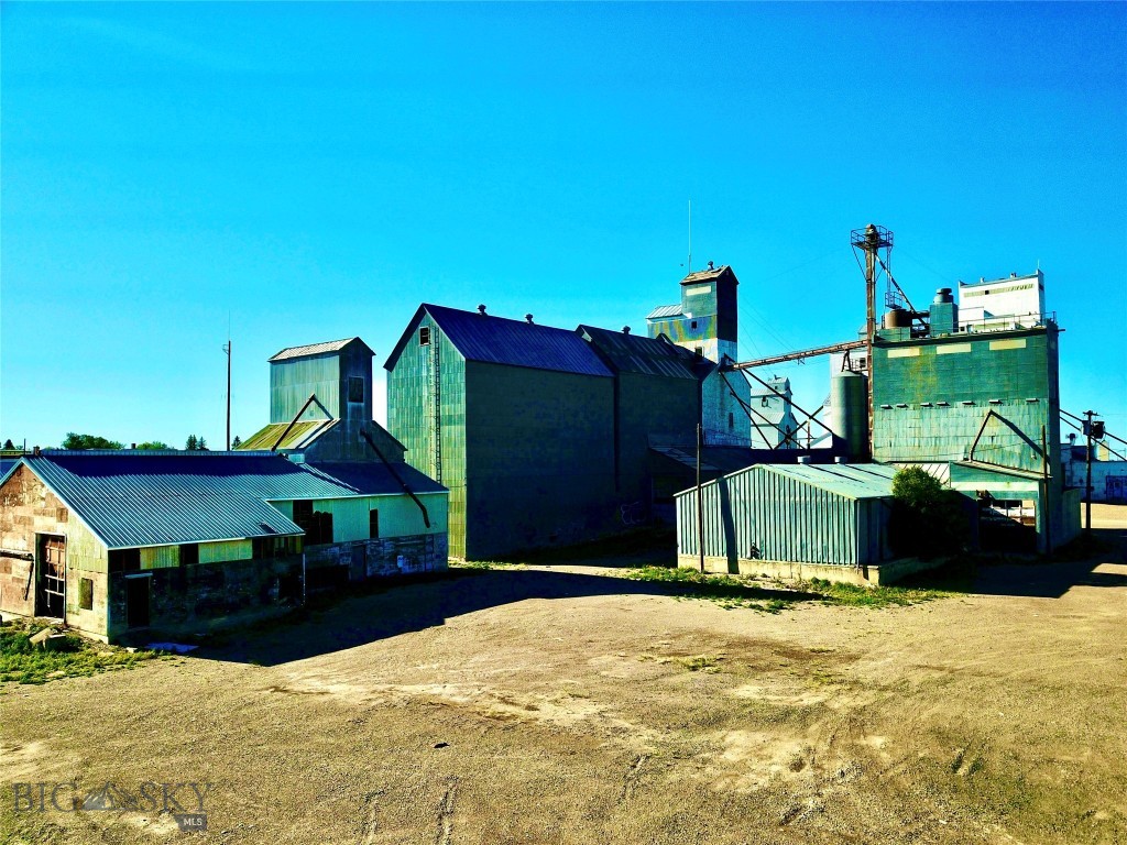 Step into a piece of Montana’s agricultural legacy with this unique commercial offering in the heart of Conrad. Spanning 1.527± acres, this property is anchored by a historic grain elevator dating back to 1910, accompanied by additional structures built between 1950 and 1975. Rich with character and history, the site reflects generations of agricultural use in one of the most productive farming regions in the state. While the structures show their age, they present potential for continued use, including grain storage capabilities estimated at approximately 269,000 bushels according to public records. The expansive lot allows ample room for semi-truck access, maneuverability, and operations—an essential feature for agricultural or commercial functionality.
Located in Montana’s renowned Golden Triangle, this property is surrounded by fertile ground known for producing high-quality grains and pulse crops, making it an ideal setting for those looking to invest in or be part of a working agricultural community.