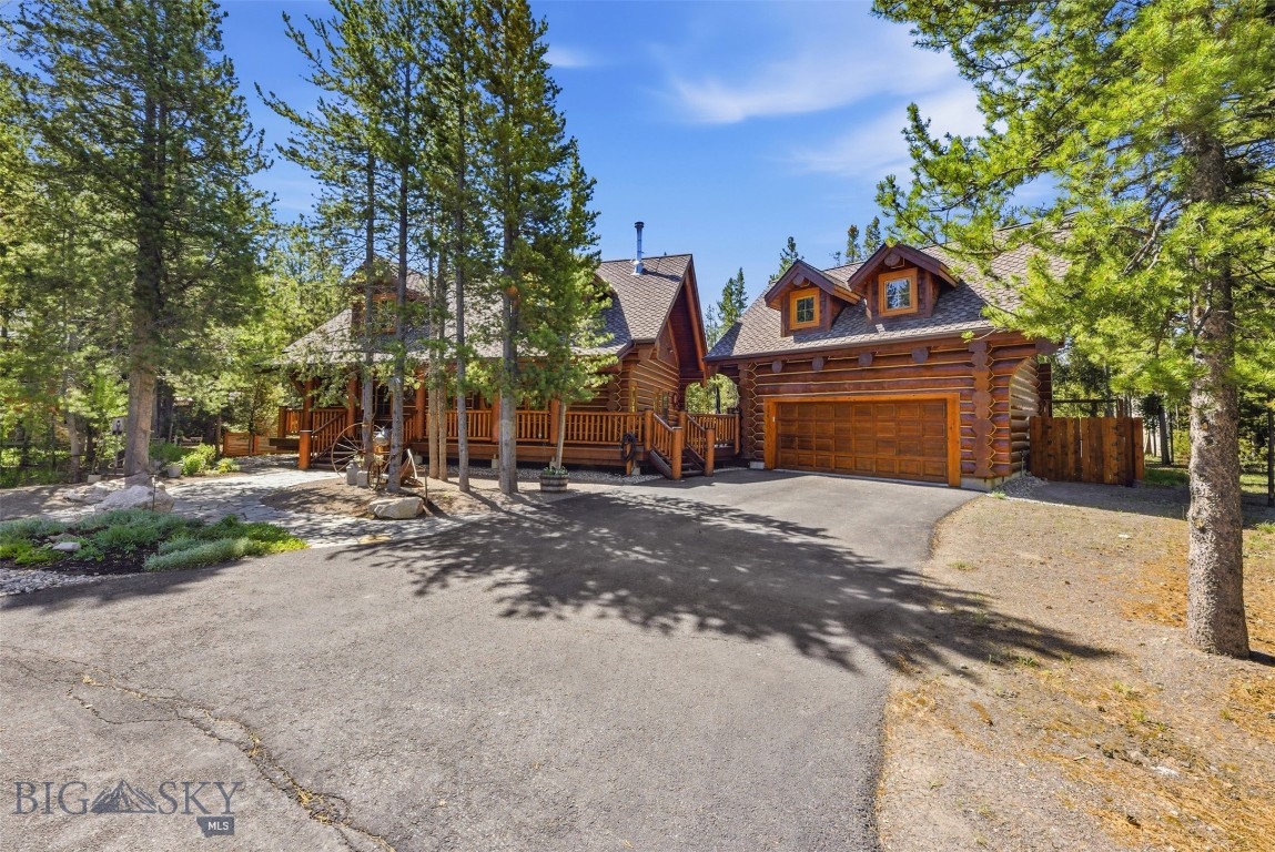 Nestled on a private cul-de-sac in Madison Addition, this beautifully maintained custom log home offers the perfect blend of mountain charm, comfort, and year-round recreation in West Yellowstone. Built in 2003, the 1,366 SF main residence features 2 bedrooms, 2 bathrooms, radiant floor heat, rich hickory hardwood floors, and a stunning rock fireplace that serves as the centerpiece of the living area. A wraparound deck extends the living space outdoors, providing the perfect place to relax and enjoy the beautifully landscaped setting. 
Situated on a .194-acre lot, the property includes a greenhouse and a detached 2-car garage with a separate entrance to the 525 SF loft apartment above with radiant baseboard heat. Complete with a 3/4 bath, the loft offers flexible space for guests, extended family, a home office, or hobby room. Some furnishings will convey, making this property even more move-in ready. Located just minutes from the West Entrance of Yellowstone National Park, this home provides exceptional access to the outdoor lifestyle that draws visitors from around the world. Nearby trail systems offer opportunities for hiking, biking, and exploring, while the area is renowned for fishing, wildlife viewing, and access to public lands. Winter enthusiasts will appreciate West Yellowstone's reputation as a premier destination for cross-country skiing and snowmobiling, with miles of groomed trails nearby. Whether you're looking for a full-time residence, seasonal retreat, or investment property, this well-cared-for home offers an outstanding opportunity to enjoy everything the Yellowstone region has to offer. Covenants require a minimum rental period of 30 days, helping preserve the character and quality of the neighborhood while still allowing rental flexibility.