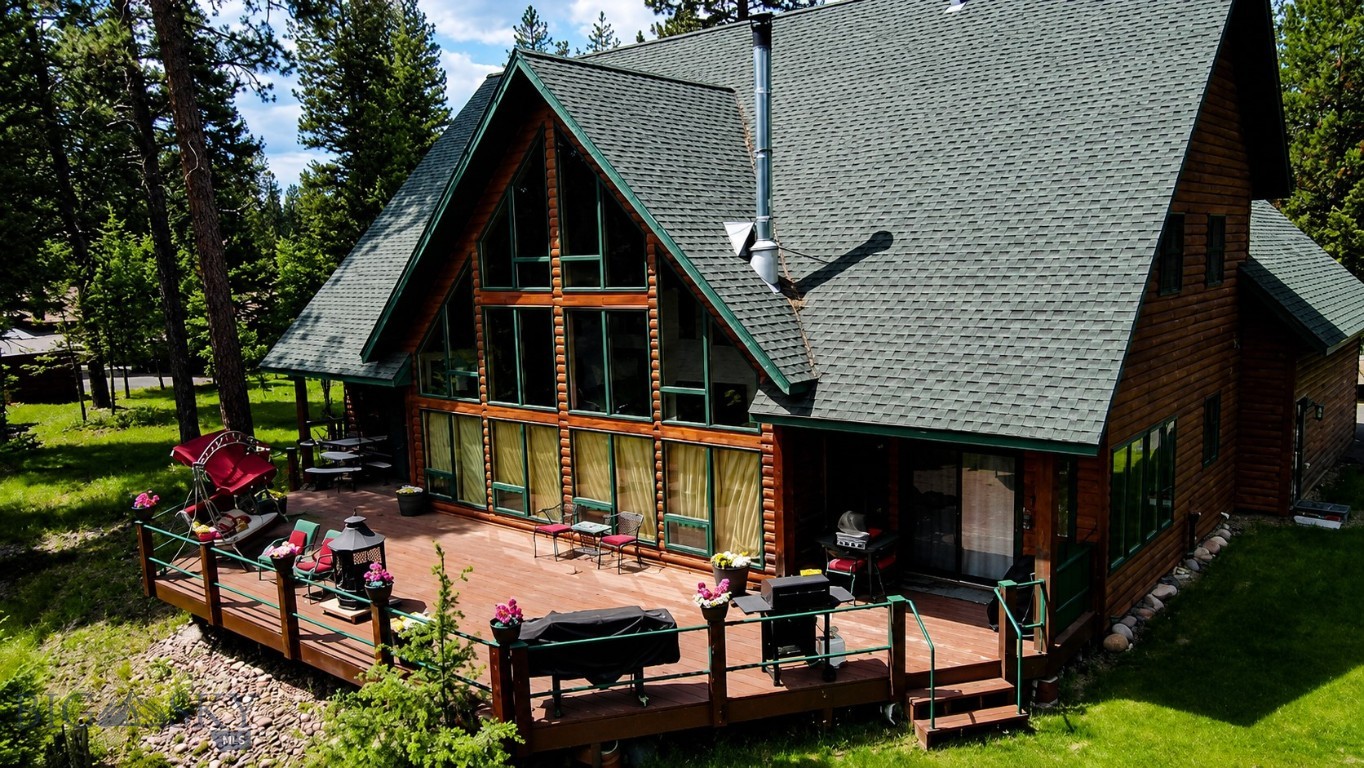 Welcome to your Montana dream retreat. Nestled among towering pines and bordered by picturesque Morrell Creek, this extraordinary 5 bedroom, 4 bathroom home sits on two parcels totaling 4.75 acres, offering a rare combination of privacy, beauty, and space. Designed to capture the breathtaking surroundings, the home features soaring tongue and groove ceilings, a stunning wall of windows, and an impressive stone fireplace that anchors the spacious great room. Natural light pours throughout the home while bringing the beauty of Montana indoors. The expansive deck invites you to relax, entertain, and enjoy unforgettable summer evenings surrounded by the sights and sounds of nature. Whether you're gathering with family and friends or simply enjoying the peaceful setting, this home was built for making memories. With multiple living areas, spacious bedrooms, updated bathrooms, and room for everyone, this property offers the perfect blend of rustic charm and modern comfort. Located in a desirable subdivision yet feeling worlds away, you'll enjoy the best of both privacy and convenience. If you've been searching for a place where luxury meets Montana living, you've just found it.