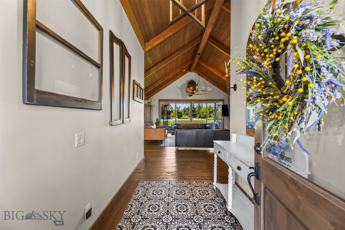 Offered to the market for the first time, this custom home in Spanish Meadows is a rare chance to own a meticulously maintained Montana property. It sits on 1.34± landscaped acres and pairs quality craftsmanship with practical, comfortable living. The great room anchors the home with wood-clad vaulted ceilings, a floor-to-ceiling stone fireplace, large windows, and hardwood floors. The chef's kitchen, with its rustic brick wall, brings a touch of Tuscany to the warmest room in the house.

More than 4,000 square feet is laid out on a smart floor plan, with the primary suite and main living areas all on one level. A dedicated den/office handles working from home, and speakers are wired throughout. The primary suite has generous walk-in closets and direct laundry access, and a separate bedroom wing, built around an oversized Jack-and-Jill bath, gives family and guests their own space.

Upstairs is a fully self-contained guest suite with its own bedroom, ¾ bath, kitchenette, and living room — a true mother-in-law suite or long-term guest quarters. The attached garage holds four plus vehicles with room to spare for gear.

The grounds are a standout. Extensive landscaping on underground sprinklers surrounds a koi pond, a private sport court set up for pickleball, and raised vegetable beds with perennial berries. A large covered stamped-concrete deck, plus a covered porch and balcony, make outdoor entertaining easy in any season.
The setting is edge-of-town in Four Corners: private, wrapped in mature trees, and close to a neighborhood park and trail system. Black Bull, Monforton School, and the full range of Gallatin Valley recreation, dining, and services are all a short drive away.

Quality construction, standout grounds, and a location that's hard to beat.
