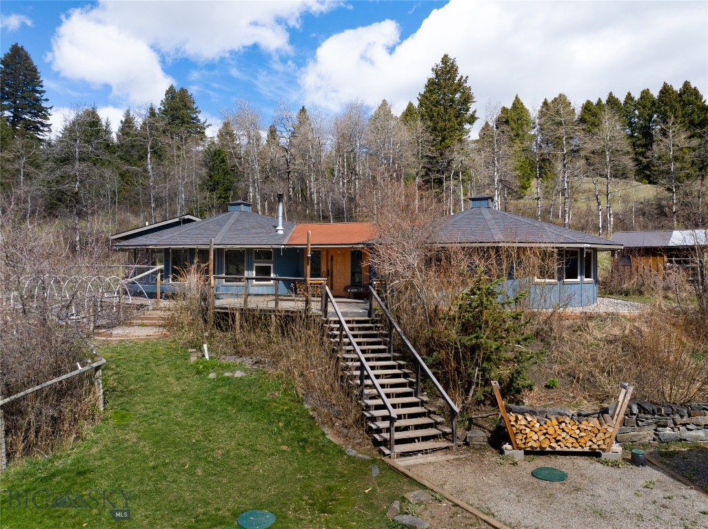 Rare Creek-Front Mountain Sanctuary in Moffit Gulch. Experience the pinnacle of Montana living on 3.4 acres tucked away on a quiet rural road in Moffit Gulch.  This 4-bedroom mountain retreat, with Pitcher Creek meandering though the property, offers privacy just 6.5 miles from all the conveniences of downtown Bozeman. The main residence finishes are rustic elegance, featuring hardwood floors, custom cabinetry, and a cozy wood stove. Oversized windows invite the outdoors in, offering front-row views of deer, elk, and moose, wandering through the pasture. Dine beside your private indoor-to-outdoor waterfall and pond, or retreat to spa-like tiled showers and a deep soaking tub.  The property is a self-sufficient haven including an over the detached garage studio fully equipped with separate utilities—perfect for a creative suite or live work office. Sustainable Living: A greenhouse with a CERES GAHT system plus 4 raised garden beds; chicken coop; a whole-house backup generator with a dedicated 500-gallon propane tank; and a whole house Viqua water purification system. This home is designed for peace of mind.  Don't miss this rare opportunity to own a piece of Bozeman's natural beauty