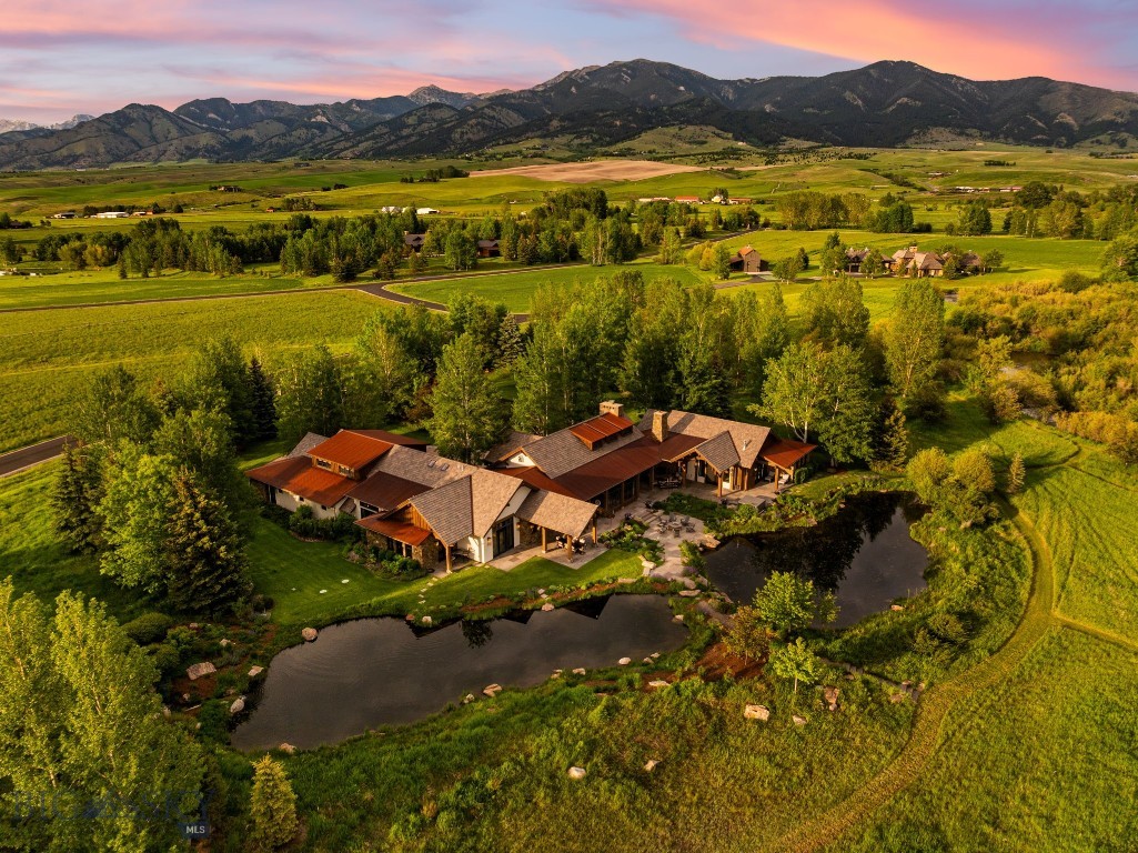 With direct East Gallatin River frontage, private trout ponds teeming with rainbow trout, sweeping vistas across the Gallatin Range, and a location just 5 minutes from downtown Bozeman, this extraordinary 20-acre estate within the exclusive Old River Farm community represents one of Southwest Montana's most compelling offerings.

Designed by renowned Locati Architects and expertly constructed by Schlauch Bottcher Construction, the residence showcases timeless mountain architecture, exceptional craftsmanship, and meticulous attention to detail. Rich walnut finishes define the home throughout, from the flooring and custom millwork to the doors and trim, creating a warm and sophisticated aesthetic that complements the surrounding landscape. Custom alder cabinetry is featured throughout the residence, adding both character and craftsmanship. A dramatic floor-to-ceiling stone fireplace anchors the great room, while curated lighting and carefully selected finishes elevate every space.

The chef's kitchen features premium appliances, stunning Taj Mahal Quartzite countertops, an oversized gathering island, and a fully appointed butler's pantry designed for effortless entertaining. The primary suite serves as a private retreat overlooking the ponds, complete with a fireplace, direct outdoor access, and a spa-inspired bathroom. A private executive office, media room, and a dedicated guest wing with three en-suite guest suites provide ample room for family and visitors alike.

Equally impressive are the grounds, where extensive landscaping has been thoughtfully designed to enhance both beauty and habitat. Mature trees, native plantings, water features, and open meadows create a sanctuary for Montana wildlife, with frequent visits from deer, waterfowl, songbirds, and other native species. Approximately one-half mile of private trails wind throughout the property, connecting the ponds, river frontage, and surrounding landscape. The two stocked ponds, home to rainbow trout and supported by sophisticated recirculation and aeration systems, further enhance the property's unique recreational appeal.

Properties of this caliber are exceptionally rare. Combining East Gallatin River frontage, world-class architecture, extraordinary craftsmanship, remarkable wildlife habitat, and immediate access to downtown Bozeman, this is a truly rare opportunity to experience Montana living at its finest.