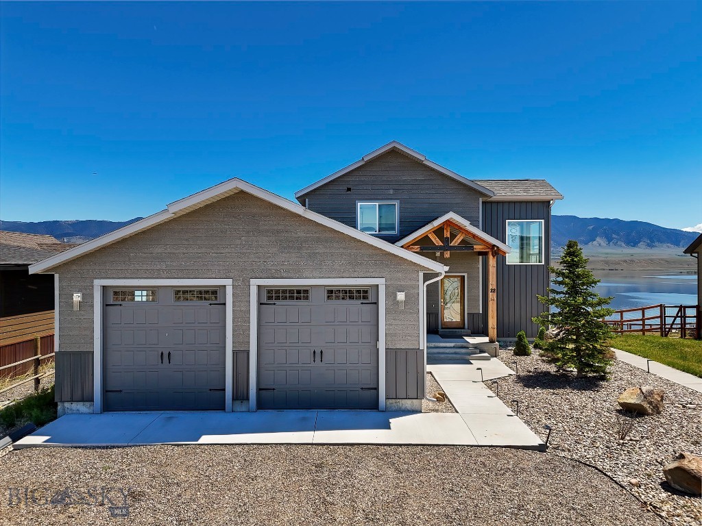 Located on the peaceful side of Ennis Lake, 22 Jordan Lane N offers 92.42+/- feet of prime lakefront location with stunning views of the Madison Range, Lone Peak, and the Jack Creek Canyon.  This custom-built home features 4 bedrooms, 3.5 bathrooms, and a total of 4,508 square feet of living space, including a 1,700 square foot apartment with 2 bedrooms, 1 bathroom, and a full kitchen on the lower level.
The spacious open floor plan includes a chef’s kitchen with upgraded stainless steel appliances, an impressive island with seating, a large hidden pantry, radiant in-floor heat, unique light fixtures and many custom upgrades.  The living and dining areas are perfect for entertaining, with a cozy modern propane fireplace as a focal point when you are not looking out the floor-to-ceiling windows to the immense view of the lake and mountains. Connect with the views even better from the wide deck that runs the width of the home. The large master suite is located on the main floor and features a soaker tub and walk-in closet and opens to the deck overlooking the lake. A second bedroom with a private bath is located on the upper level.
The lower level is ideal for guests or family members and  has two additional bedrooms, a full bath, and a second full kitchen, all with direct access to the outdoors and a private entrance. A spacious patio and sidewalk area provide ample space for outdoor living and recreation at this level.
The property offers private lake access on a path from the house, and the potential for a dock to be added for water access. There is extra gravel parking for guests.  Enjoy a peaceful lakeside retreat with fishing, boating, and breathtaking mountain views. Additionally, the property allows for short-term rentals, making it a versatile investment or recreational property. This home lives well as a primary residence or as an investment property with income potential and is being offered furnished.