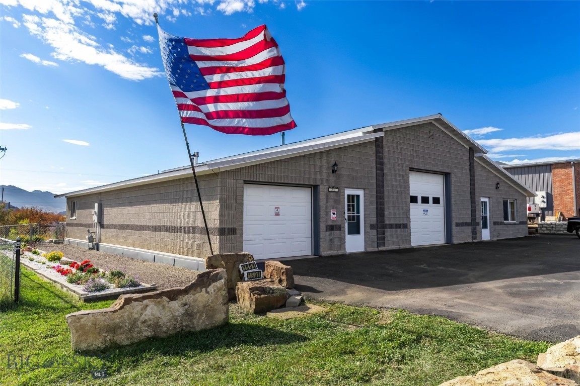 Set on three commercial lots totalling .75+/- acres just minutes from downtown Livingston, 1801 Sun Ave offers versatility and elbow room with a layout designed for living, working, and creating. This unique 3,456± sq ft structure combines a well-maintained main residence, an attached studio-style ADU with a private entrance, and a heated shop with a 12’ electric door and vehicle lift (negotiable)—ideal for car enthusiasts, woodworkers, or anyone needing space to build and store. Each living unit has its own garage, ensuring you won’t have to take up shop space for vehicle storage. The main home includes two spacious bedrooms—one on each end of the home with their own en suite bathrooms— tall ceilings, abundant natural light, and thoughtful updates including new landscaping with privacy fencing and freshly sealcoated paved parking, with plenty of room for your vehicles, toys, or business traffic. The attached ADU features its own entrance, a ¾ bath, and a flexible studio layout with laminate and carpet flooring. Highly insulated with zip panel and concrete construction, this property is energy efficient and built to last. Outside, the yard is fenced and includes raised garden beds, and room to expand. The property borders additional lots (included in the sale) that offer increased privacy and development potential. The East side of the property is edged by Fleshman Creek, and mature apple trees line the western boundary. With unobstructed views of the Absaroka Mountain Range, and space for projects, guests, or business expansion, this is a rare opportunity in Livingston for those who value function, freedom, and flexibility. Residential Listing: 406178, Commercial Listing: 406291