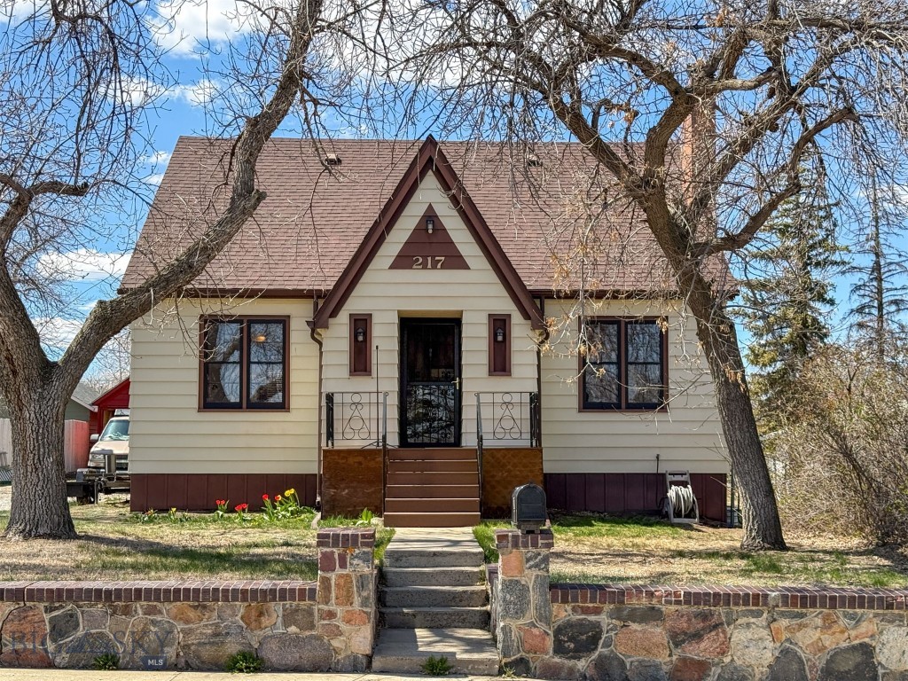 You’ll love this classic, tudor-style home, featuring charming details from the past, including built-ins, archways, and real hardwood floors, while also incorporating tasteful updates such as a tiled shower and double-sink vanity. The living room invites you to relax by the wood-burning fireplace and flows into a formal dining room, which leads to a kitchen with an additional eating space and an abundance of storage and cabinetry. Also, on the main floor, are two bedrooms and a full bathroom with shower/tub. The lower level offers a recreation room, another full egress bedroom, with newer laminate flooring, a flex room, spacious laundry area, and a beautifully-remodeled bathroom. On the way up to the second level, you’ll appreciate the inviting wooden staircase with a landing at the top and find an over-sized primary bedroom with a walk-in closet, along with an additional bedroom. The property is partly fenced and features mature landscaping with large shade trees, attractive shrubs and a real stone wall with steps that take you to the original real-wood front door. Out back, there is plenty of space to sit and barbecue on your Trex deck. A detached two-car garage—recently painted—provides plenty of additional space. Shelby is a small rural town with full services and with close proximity to hunting, fishing, recreation and a short drive to Canada and Glacier National Park. House should go VA, FHA and RD.
