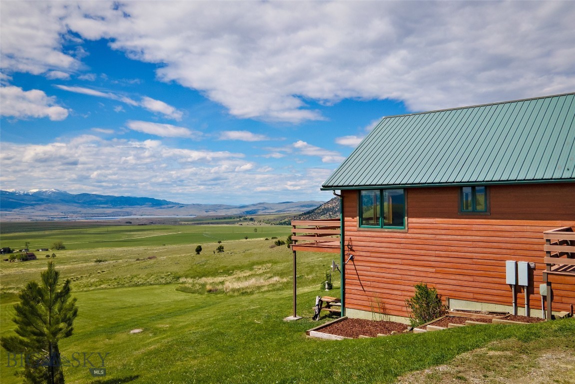 Rare Opportunity to Own this 20± Acre Montana Retreat in an Exceptional Location with Incredible Views!!
Nice cabin style home in the desirable Double M Ranch Subdivision with expansive views and a peaceful end-of-the-road setting. 
This 2,296± sqft. 3 bedroom, 2.5 bath home comes partially furnished and is ready for immediate enjoyment. Inside, the home offers a warm and welcoming atmosphere with vaulted ceilings, expansive view windows, hardwood flooring, and a cozy wood stove that adds to its authentic Montana charm. The open-concept living area flows into the convenient kitchen featuring an island and eating bar, creating an ideal space for gathering and entertaining.  Step outside from the living room onto the wraparound deck to enjoy morning coffee, summer BBQs, and incredible mountain, valley and lake views while watching elk, deer, fox, and other wildlife that frequently wander through the property. The main floor also includes the primary bedroom suite featuring a spacious bathroom with tub and separate shower.  Laundry room and 1/2 bath. 
The lower level includes 2 bedrooms, 1 bath and a comfortable family room that opens onto a covered patio area, creating a great space for relaxing and enjoying the scenery. Enjoy the views of Ennis Lake, Madison Valley, Gravelly Range and Tobacco Root Mountains all while surrounded by abundant wildlife.  Don't miss out on seeing this amazing property!!