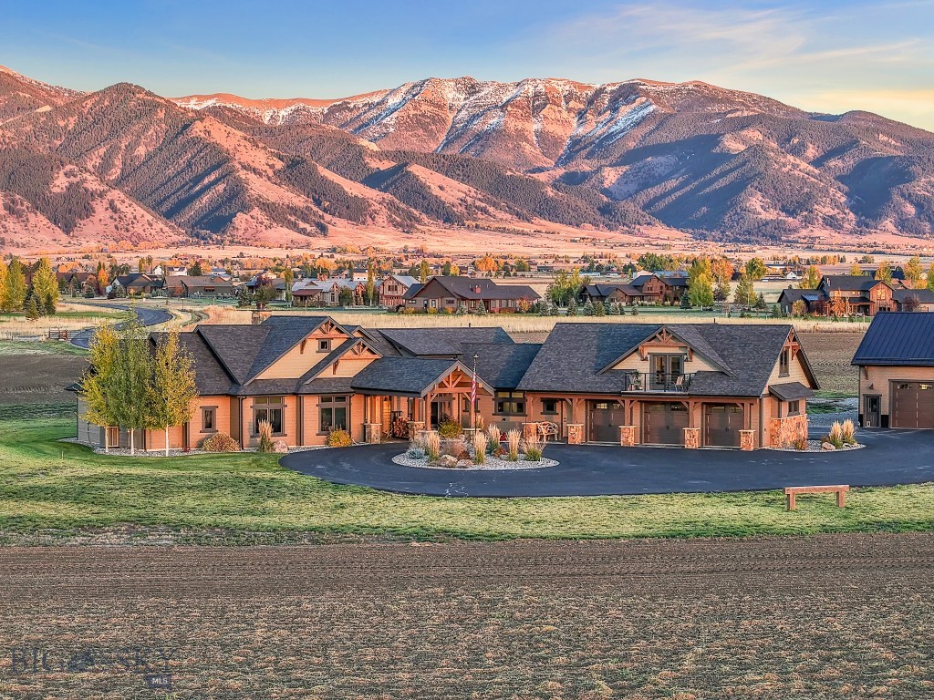 Discover the essence of Montana living on this remarkable 40-acre estate. Located within a gated community with an additional private, paved entrance through Spain Bridge Meadows, the property offers unmatched privacy surrounded by natural beauty. Residents enjoy community access to the Gallatin River along with walk and ride easements for effortless outdoor recreation. Inside, natural light fills the home through expansive windows that frame the mountains from nearly every angle. Beautiful timberwork runs throughout the main living areas, and a dramatic wood-burning fireplace anchors the great room. A beautifully appointed wet bar adds effortless convenience for hosting. The dining area opens fully to the covered patio through an accordion glass door, creating a seamless indoor–outdoor experience with an outdoor kitchen, wood-burning fireplace with gas starters, overhead heaters, a ceiling fan, and a hot tub, an ideal setting for year-round entertaining.The north wing includes an office, gym with rubber floor and the primary suite with expansive views, remote controlled blinds and a spa-like bath with a walk-through shower and tanning room. The south wing offers two bedrooms, a guest bath, pantry, laundry room, and access to the basement, garage, and attached guest apartment/suite- perfect for an au pair, multigenerational living, or long-term guests. A rare highlight is the fully equipped underground gun safe and 100 yard shooting range with vault door, pegboard gun holders, sound barrier, HVAC & ventilation system, retractable target system and camera system for target viewing, an extraordinary amenity that sets this property apart. With approval for up to three structures and room for four horses, the property offers exceptional flexibility. Just minutes from Bozeman, this estate blends luxury, privacy, and the wild beauty of Montana into a spectacular Montana sanctuary.