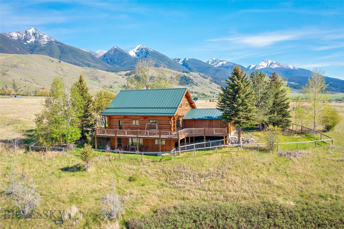 Nestled in the heart of Paradise Valley, this extraordinary log home captures the Montana lifestyle buyers dream about: privacy, breathtaking scenery, and year-round adventure surrounded by the rugged beauty of spectacular mountain ranges. Set on ten secluded acres with sweeping views of snow-capped mountain ranges and south to the uplands of Yellowstone National Park, this is a place where fishing, hiking, biking, rafting, and quiet connection to nature become part of everyday life — with private Yellowstone River walking access available exclusively to HOA members.

Inside, the warm and inviting home offers an open-concept main floor with soaring ceilings, expansive windows, and abundant natural light, creating an ideal setting for both relaxed living and entertaining. The wraparound deck provides a front-row seat to peaceful sunrises and dramatic Montana sunsets.

Upstairs, the spacious loft-style primary suite offers flexibility for a home office, reading retreat, or fitness area. The bright walk-out lower level—with its own private deck—includes two additional bedrooms, a full bath, and generous living space perfect for guests, multi-generational living, or a potential short-term rental opportunity. Comfortably accommodating up to ten guests, this property offers exceptional income potential as a vacation retreat.

Surrounded by mature pines and aspens, the property also includes a charming garden area and unmatched tranquility. Located just 20 minutes from the historic and increasingly vibrant town of Livingston—known for its restaurants, galleries, and western character—and less than an hour from Bozeman and its international airport, this home offers both seclusion and accessibility.

The log house on Rocky Hollow is waiting:don't miss your chance to own an paralleled connection to the rugged beauty of the New American West.