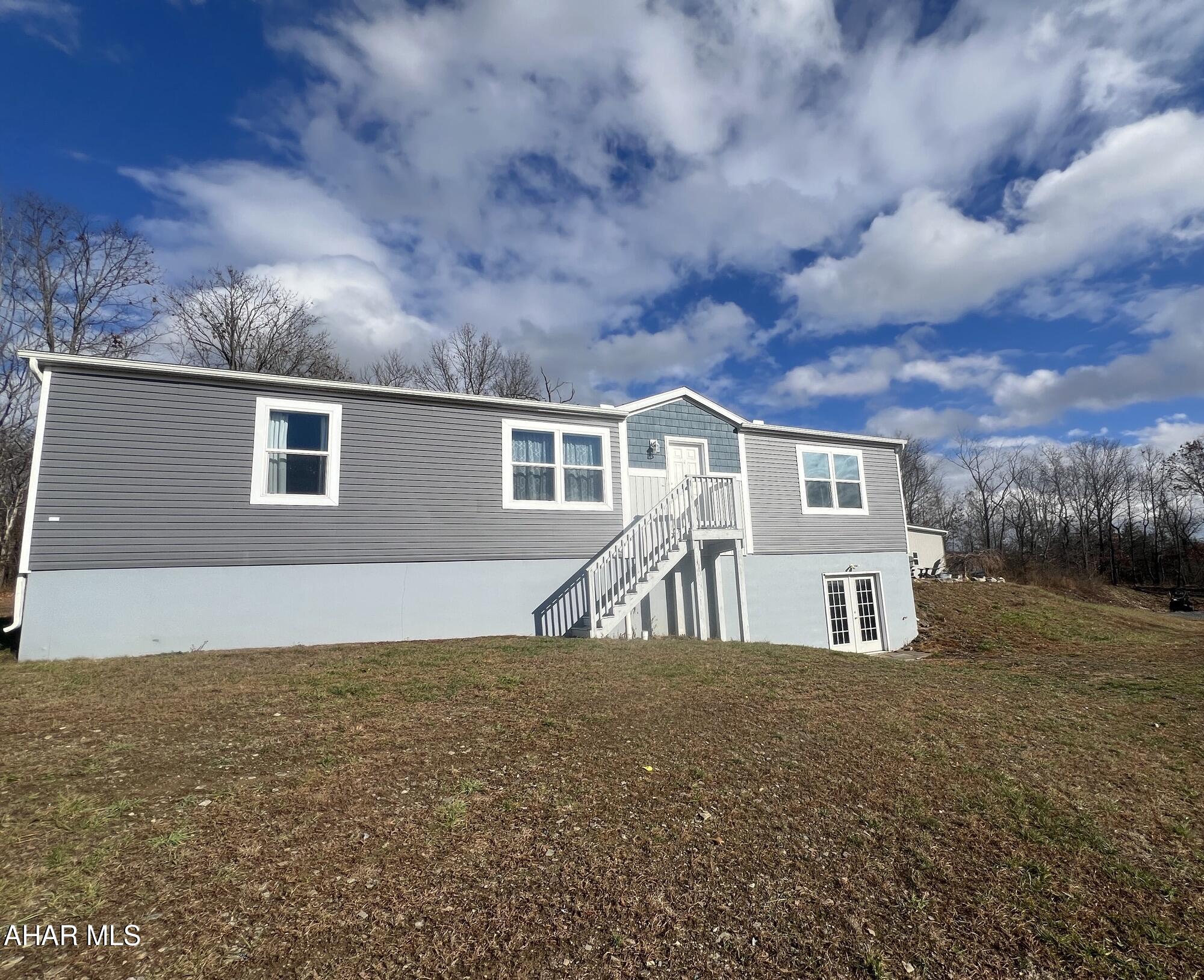 If tranquility is what you are seeking, this house is for you - privacy, acreage and a move-in ready home. This spacious double wide home, with a retired title sits on a permanent full, walk-out basement on 5 secluded acres.  The main floor features an open layout with 3 bedrooms, 2 baths and the convenience of first floor laundry. The finished lower level includes a spacious family room and two bonus rooms, kept warm and cozy with a pellet stove. This property offers relaxed country living with space to grow.