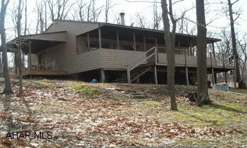 Cross New Baltimore covered bridge and when road ends turn right, take immediate right. Cabin approx 1/4 mile on right. 10 mostly wooded acres - furnished cabin!  Move right in and enjoy this furnished cabin that has been very well maintained.  Most recent improvements include roof, vinyl siding, propane stove, porches, carpeting, pergo.  Be close to fishing and hunt on your own property!  This is priced to sell quickly at $99,900.  Call Tina @ 814.242.2047.School district: Berlin Bros. Valley, Somerset County.