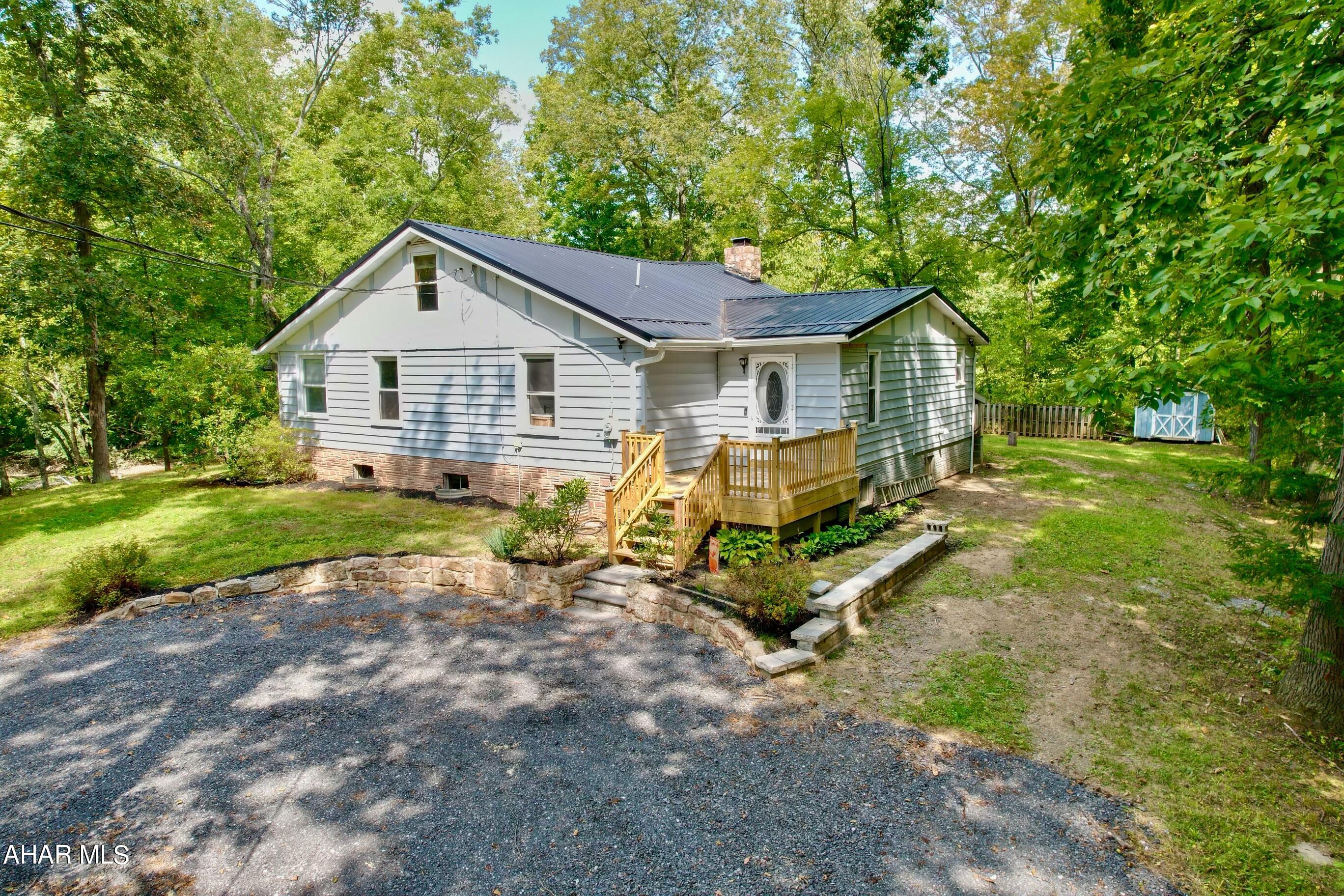 Sit on the deck, listen to the water flow down the river, watch the wild life drink from the stream, or fish off the land from this cabin in the woods.  This private setting is on Dunnings Creek with 1.5 acres.  It has 4 bedrooms with a bonus loft.  The open floor plan is great for entertaining or family gatherings.  This home has plenty of room for all your guests and includes remodeled bathrooms, kitchen, flooring, furnace, and so much more.  There is space for everyone indoors and outdoors. This can be used as a vacation rental or a full time residence.  There are so many possibilities! Close to Blue Knob State Park, Shawnee State Park, I99, Rt 56, PA Turnpike