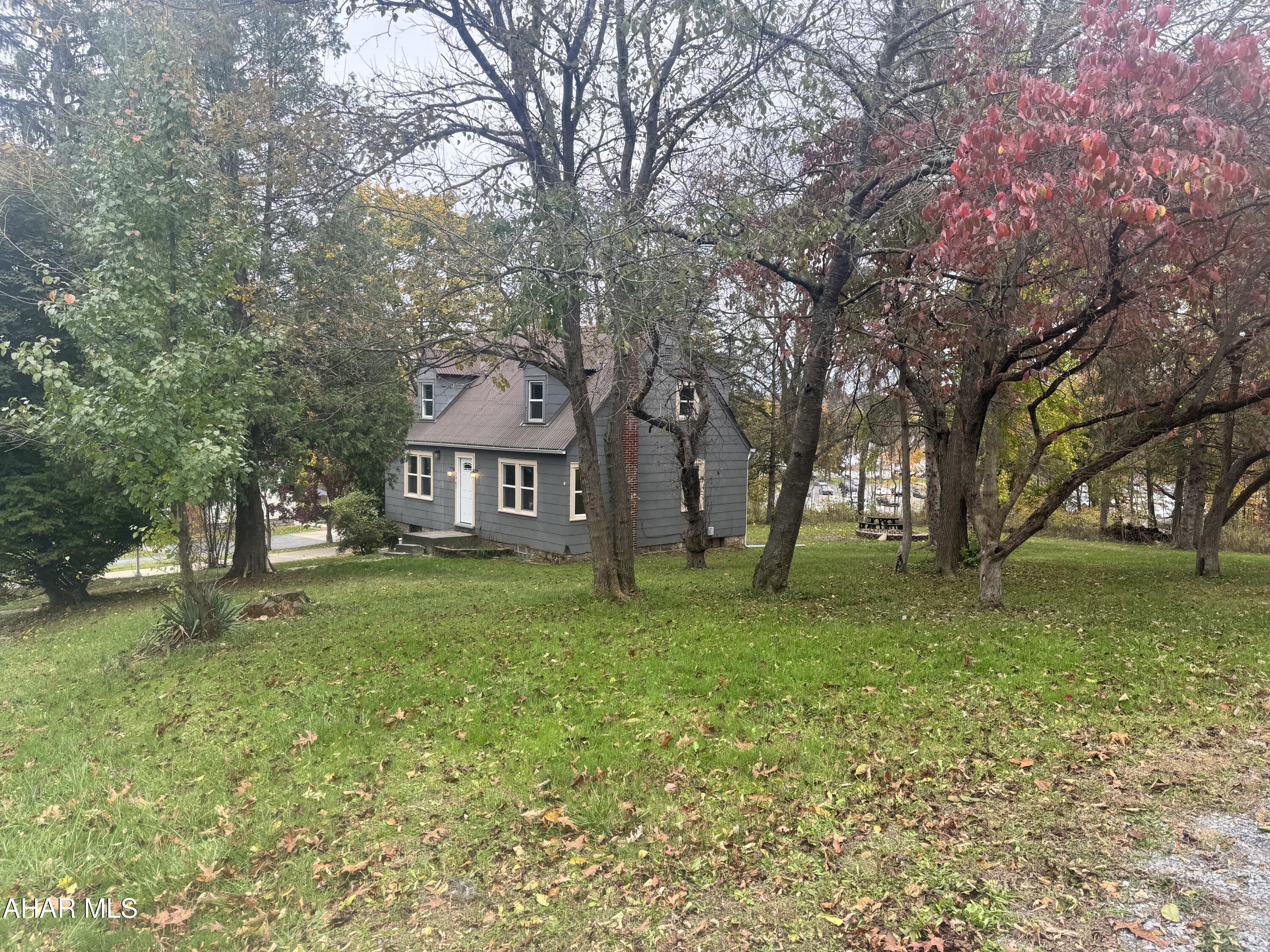 This charming 3-bedroom, 2-bath home offers an extraordinary opportunity on a spacious 0.65-acre lot, providing a rare blend of privacy and unbeatable convenience as it sits directly in Penn State Altoona campus's backyard. Imagine the ease of walking to classes or work via the private path directly behind the property, all while enjoying a serene setting surrounded by mature trees. Inside, you'll find great potential, including two large upstairs bedrooms with multiple closets, and recent upgrades like new stairs off the back deck. While the property needs TLC, its prime location and generous lot size make it an ideal candidate for both a rewarding forever home project or a highly sought-after rental investment in the competitive Altoona market.