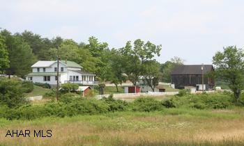 197.22 Acre Farm w/2-story vinyl 3BR/1BA house, located in scenic countryside of southern Bedford County. 197.22 Acre Farm w/2-story vinyl 3BR/1BA house; LR, DR, kitchen, enclosed sun room.  Located in scenic countryside of southern Bedford County.  Acreage includes approx 30 acres open fields, 165 acres wooded, and approx 8 acres partially fenced. 2 acre stocked spring fed pond is 6-12' deep.  Outbuildings include:  40'x42' barn, 17'x19' detached garage, 8'x12' garden shed, 12'x15' maintenance shop, 12'x21' storage shed and corn crib.  Stream on property.  Relax and enjoy the beautiful countryside and mountains.