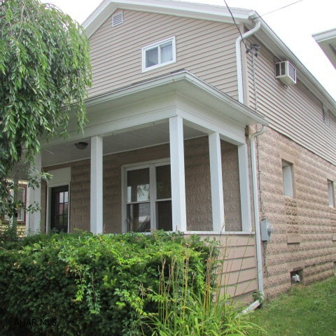 In Smithfield, 3 bedroom 1 bath home.  Has newer 2007 kitchen with appliances and newer bath. Has foyer area with vinyl and coat closet. Living room w/ceiling fan and big windows.  Dining Room has laminate and wood on lower walls.  Nice big newer bath with linen area.  Hallway upstairs has a large closet. Newer windows and roof - home was updated in 1997 and also 2003. Three season room off the kitchen that leads to the deck/pool area.  Pool size - 15' diameter.  Lot goes to the alley.  Backyard is fenced plus has off-street parking at alley. Nice 22x7 front porch with a weeping cherry tree in front - great for some privacy. Very low utilities!