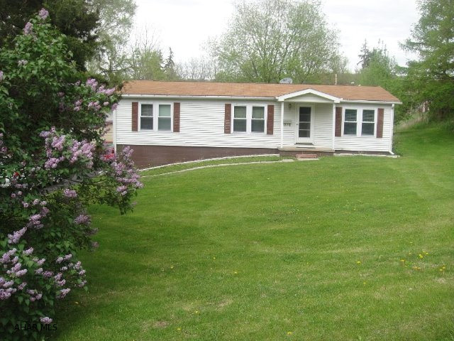 Well kept double wide on over 1/2 acre with 24' x 35' garage. 3 BR, 2 BA with 24' x 10' covered rear porch with full basement under porch. Quiet location with exceptional yard and black top driveway. Close to town with a rural feel. Don't let this one get away.
