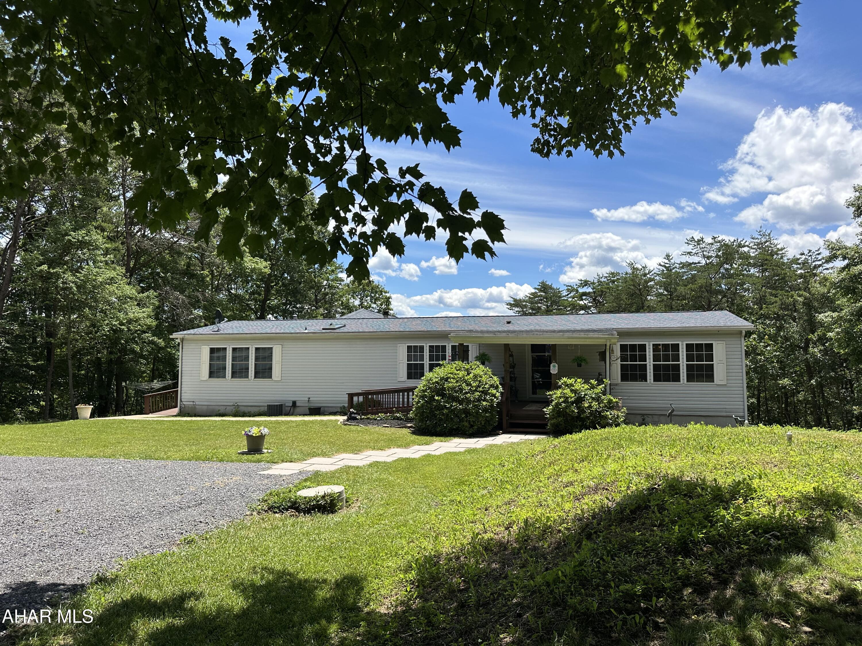 Located with in minutes to Raystown Lake this country setting offers peaceful escape, privacy, large mature trees and a panoramic view.  The home has an open-concept floor plan utilizing seamless transition between the kitchen, living and dining area.  Enjoy spending time on the front porch or the view from the large rear deck.  The detached oversized garage provides ample storage space for all your out door toys.