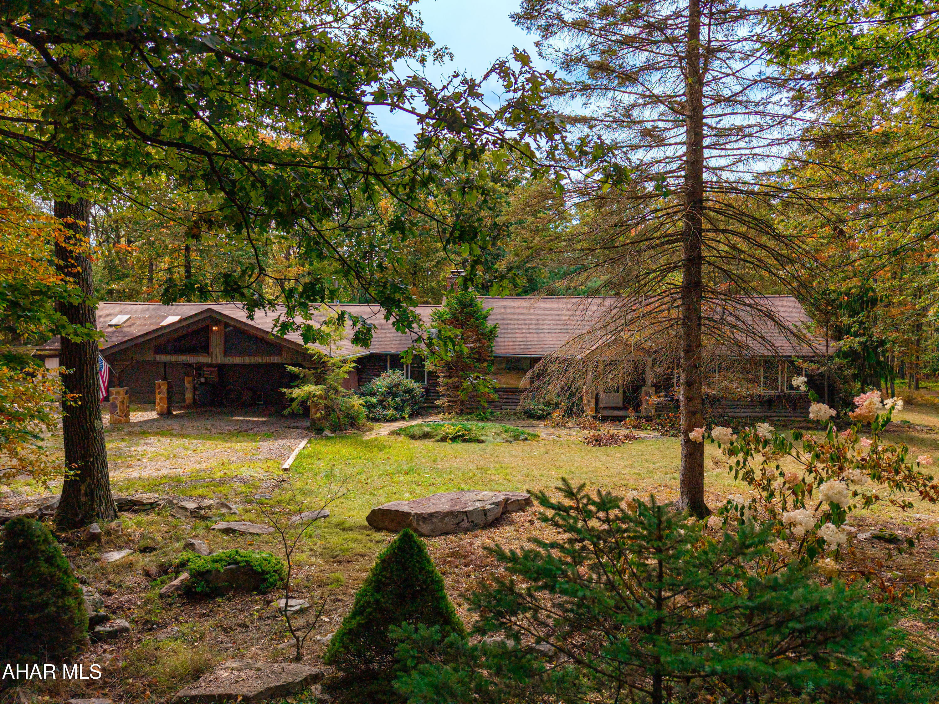 Nestled in the Allegheny Mountains on 15.1 acres, this log home offers, peace, tranquility, and scenic wooded views!! This home offers a great room with stone fireplace and cathedral ceiling, dining room, kitchen, two bedrooms, two bathrooms, a sunroom, and a mud room on the main level. Second level has a loft and a finished bonus room perfect for storage, playroom or small office. Three-car attached garage, and a two-car carport. Full basement, 200-amp electric with generator transfer switch, oil FA heat, wood/coal stoves, propane stove, and a mini split heat pump in the sunroom.  Private setting with a driveway gate, mature trees, level to gently sloping landscapes, and ferns growing among the forest floor. Easy access to State Route 30 and state game lands, close to Shawnee State Park, and a short drive to historic downtown Bedford. Within an hour or two of Seven Springs and Hidden Valley Resorts, Ohio Pyle State Park, Pittsburgh, PA, Blackwater Falls State Park, WV. Year -round living or your perfect get-away property to just enjoy nature. With some updating and remodeling, this could be a beautiful home!!