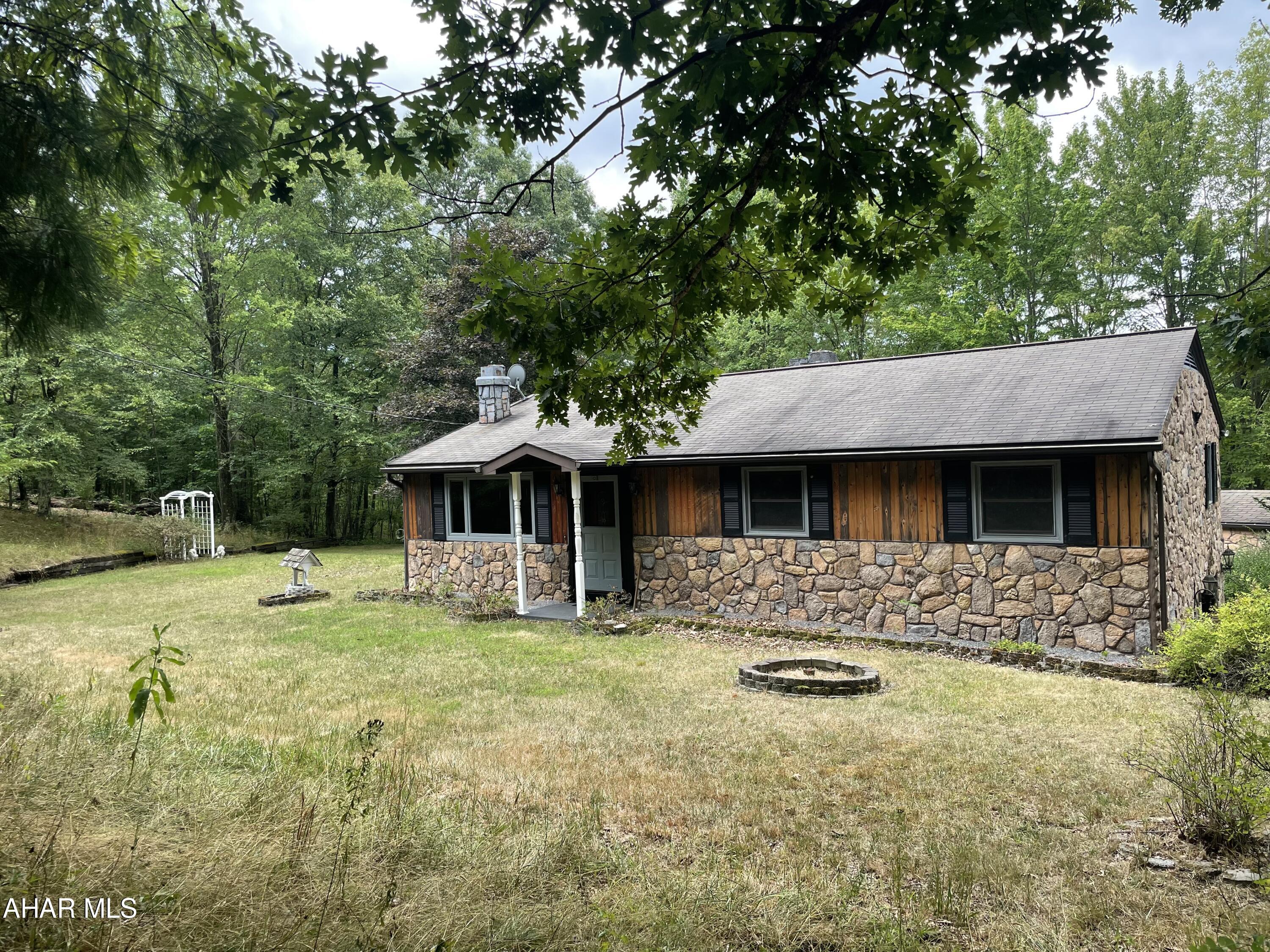 Secluded ranch style home with 2 acres in Logan Township. This 3 bedroom 1.5 bath home features: an eat-in kitchen, spacious living room with fireplace and bult-in gun case, floor laundry room with utility sink and closets, primary bedroom has a 1/2 bath. Plenty of closest throughout house.  Partial finished basement. Partial covered deck. Integral 1 car garage. Detached 1 car garage. 2 car carport. Shed.