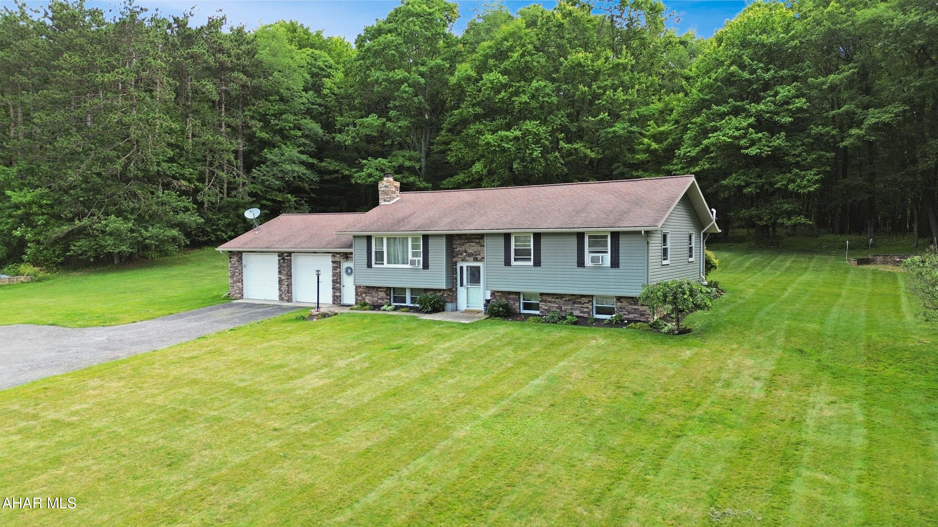 Welcome to 1539 Colver Road in the Central Cambria School District! Nestled on a private, level one-acre lot, this beautifully maintained split-level home has been tastefully updated and offers the perfect blend of comfort, functionality, and outdoor living. The main level features a spacious living room filled with natural light, a formal dining area, an attractive kitchen with solid oak cabinetry, three generously sized bedrooms, and a beautifully updated full bathroom complete with a custom tile shower. The finished lower level provides exceptional additional living space, highlighted by a large family room with a cozy propane fireplace, custom built-in cabinetry, a wet bar ideal for entertaining, a versatile bonus room, an updated full bathroom, and a convenient laundry area. Outside, you'll enjoy an attached two-car garage, a large storage shed with a covered porch and lean-to, a fire pit area, concrete basketball court, expansive covered composite rear deck, relaxing hot tub, and plenty of room to enjoy the peaceful surroundings. This move-in ready property truly has something for everyone - schedule your private showing today!