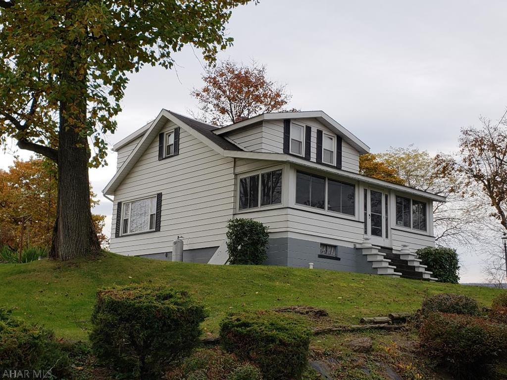 Nice 3-bedroom aluminum-sided Cape Cod with eat-in Kitchen, formal Dining Room, enclosed front porch, newer vinyl windows & nice view on double lot.  J-466