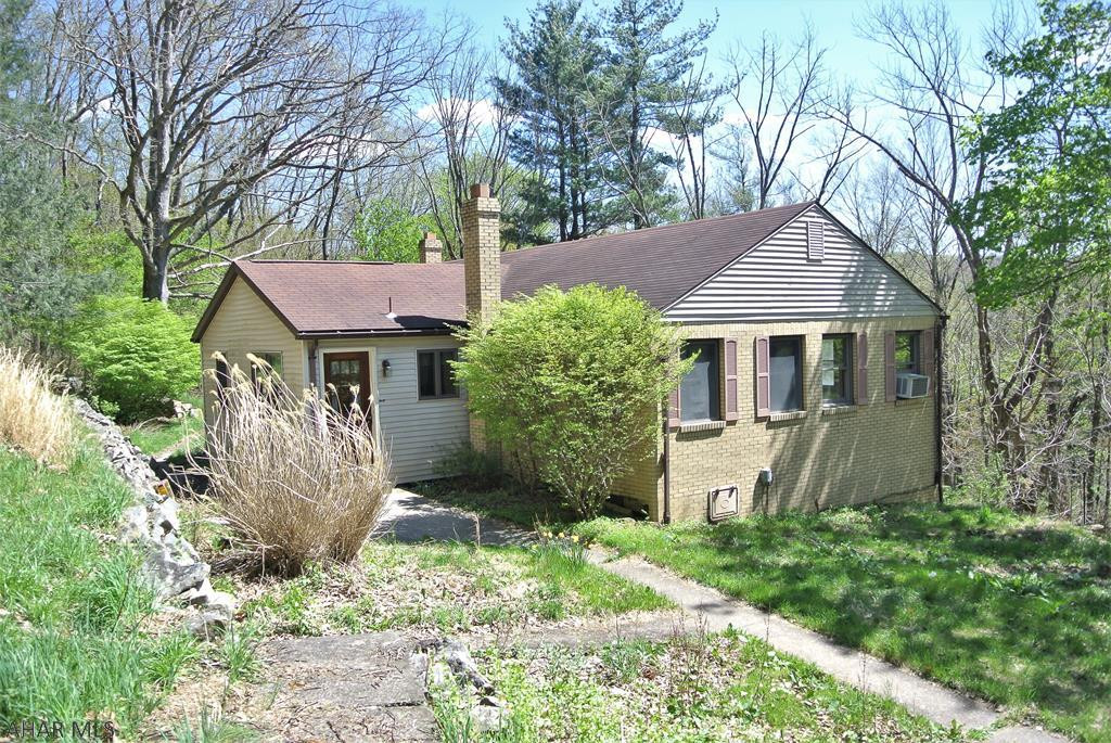 LOOK.....Acreage! ! You've been searching sooo long for a home with a little private acreage but still close to town...Well, NOW YOU HAVE FOUND IT!!  This one story solid brick home sets on 3.5 acres just past the Altoona Campus.  This home currently offers newer light Cherry Kitchen Cabinets, hardwood floors, 1st floor laundry, 8ft ceilings in the basement with a walk-out at ground level, and a huge family room with a stone fireplace!  The grounds have a detached garage  w/ a bonus room above, parking space in front and behind, an old pavilion w/ a wood stove that was used for family gatherings.  This home has sat vacant for awhile and now just needs a little TLC.  It needs a new famiy to give it life once again...  It has been priced well below the 217k assessed value.. to do just that!