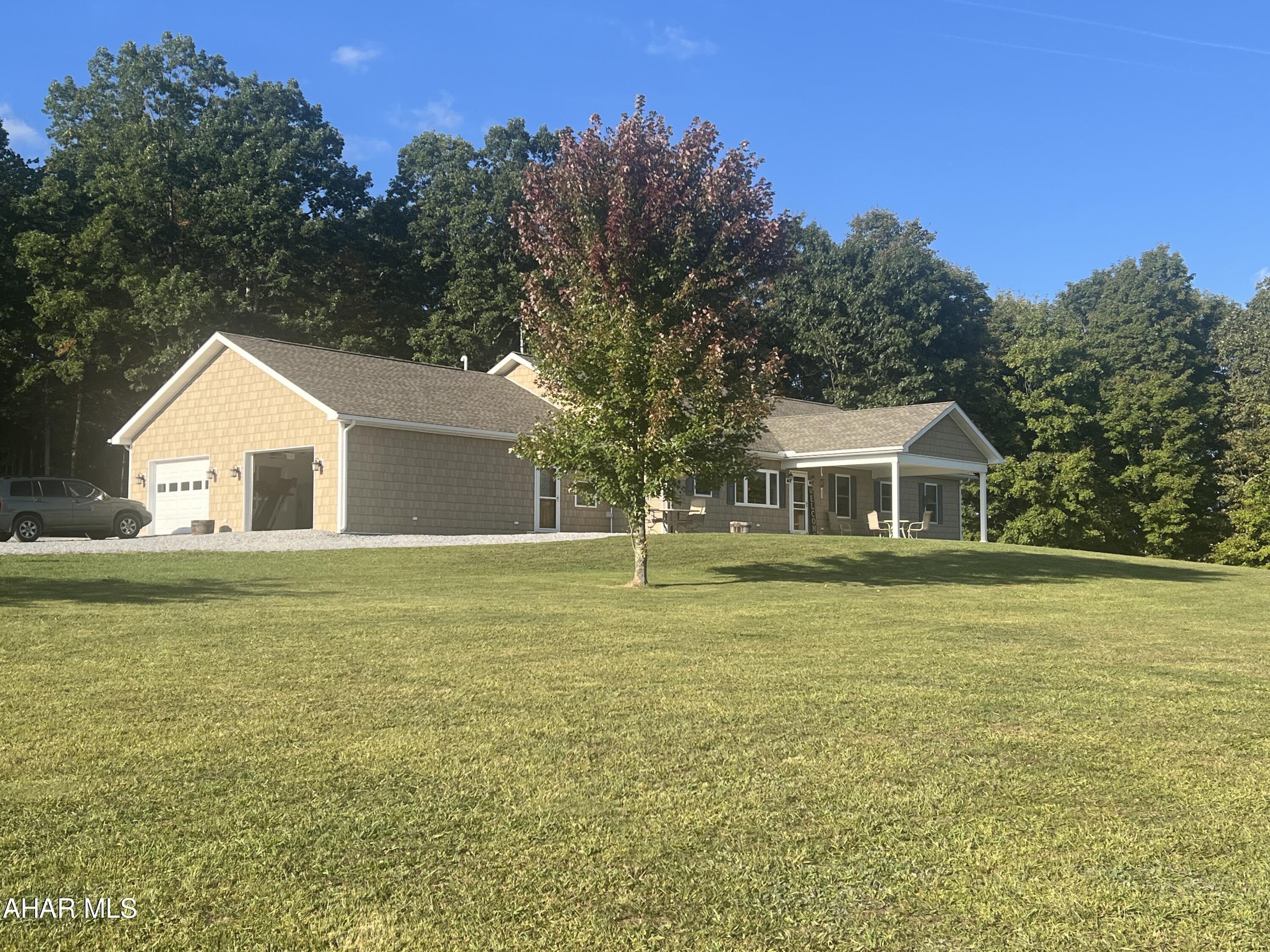 Looking for paradise ? This home may be it. Solid well built rancher on over 21 acres featuring 5 bedrooms, 2- 3/4 baths and a full bath, large custom hickory kitchen with open dining room, and large living room. Attached two+ car garage and a front porch and rear covered deck. The detached garage measures 28 x 80 with a 16x34+/- addition.  Generator hookup and a camper door/storage. 5 zone propane heating and an outdoor wood, coal boiler. This home has a great view and a private setting. Small pond on the property. Hunting stands can be included.