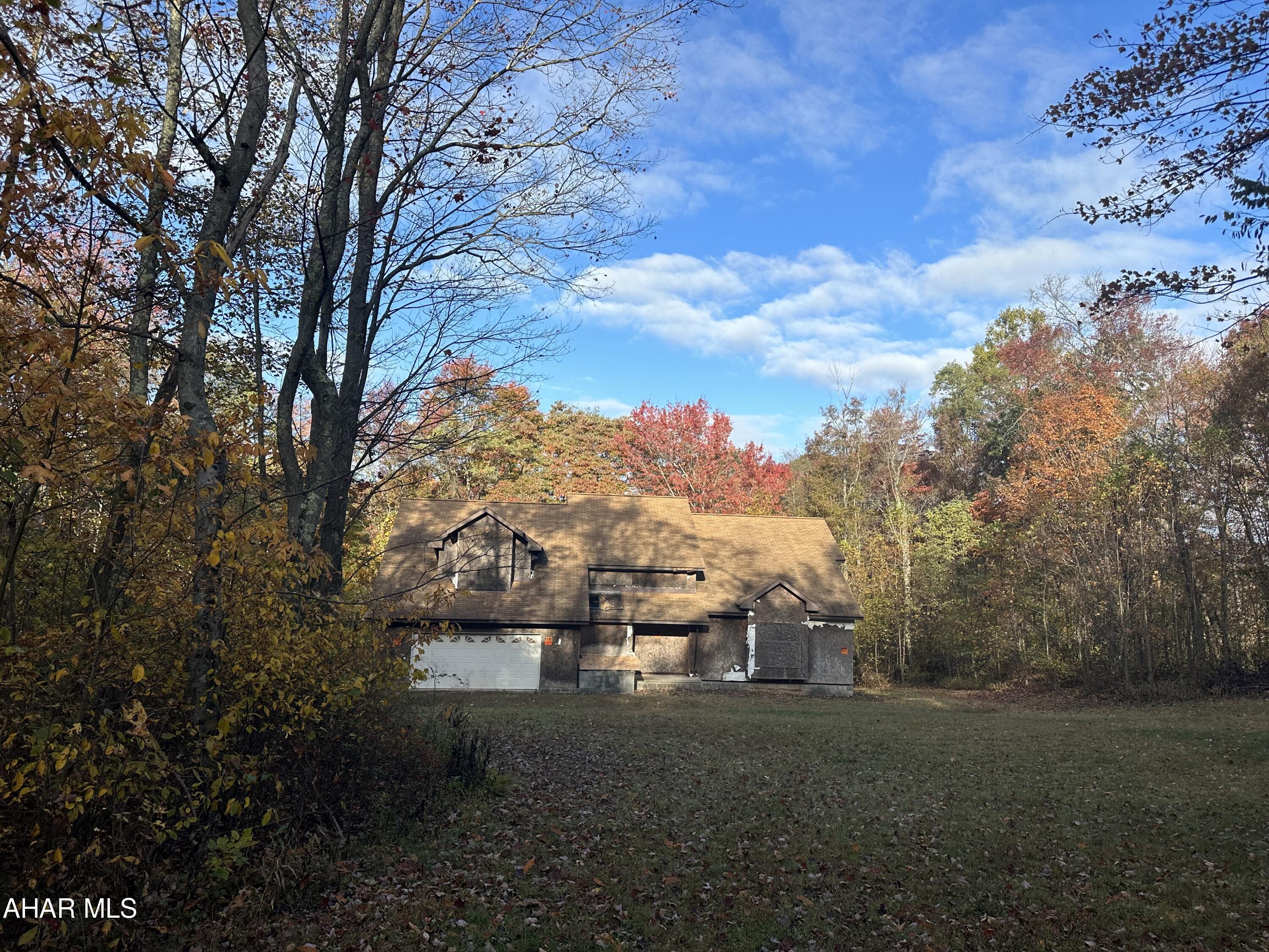 Pristine 42 acres, very private wooded acreage with unfinished house, stream meanders through the property, house is under roof with windows, full basement with stone floor, lots of potential in this spacious 1 1/2 story, well and septic are installed, electric needs run to property, dirt road access