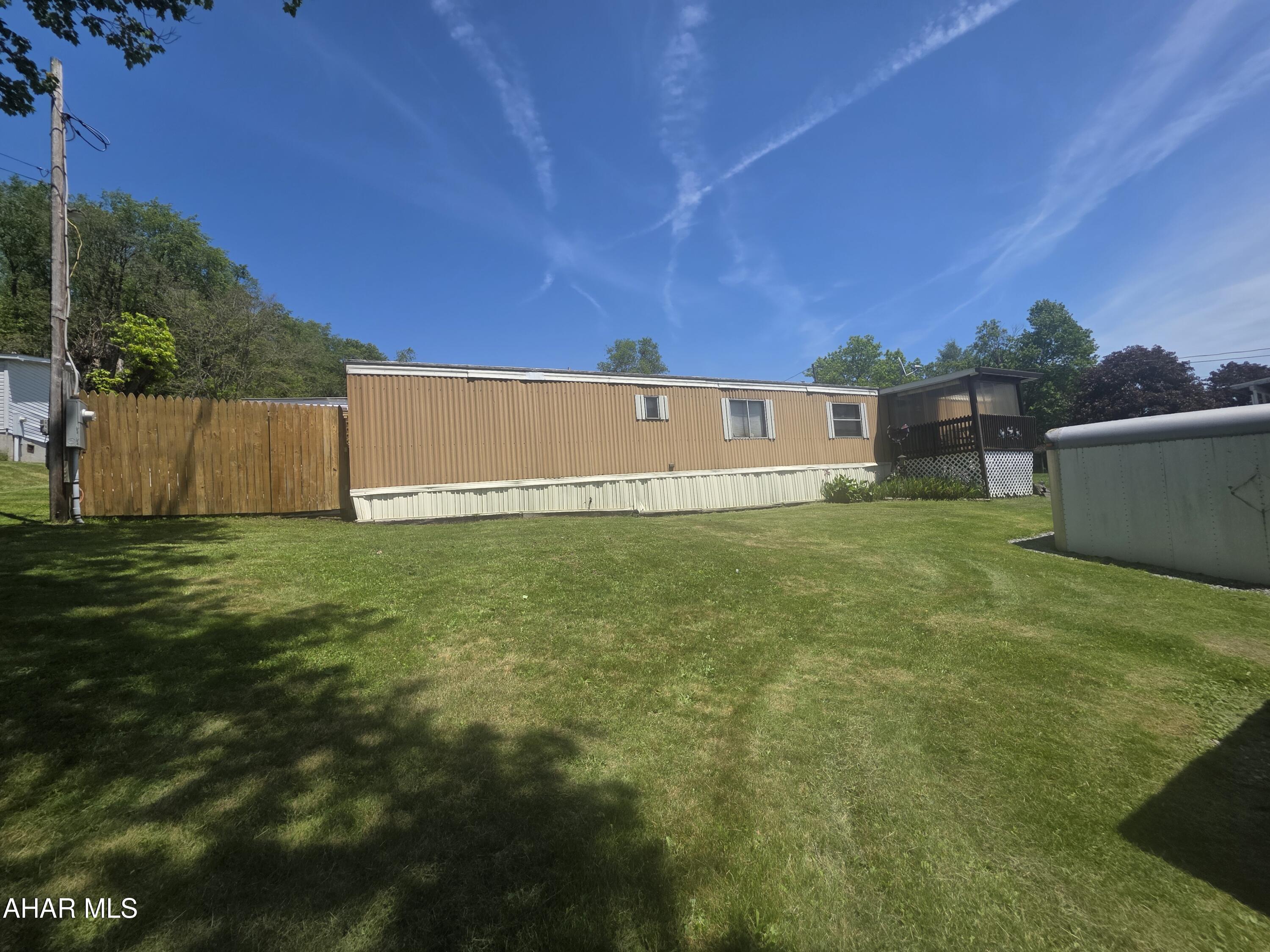 This 1983 single-wide manufactured home sits on a manageable 0.27-acre lot, offering a cozy and practical layout. A welcoming front porch deck leads you into the interior, which features a functional kitchen, a comfortable living room, two bedrooms, and a full bathroom. Outside, the property is equipped with useful outbuildings perfect for extra storage or hobby space, while a fully fenced-in side and front yard provides a secure area for pets, gardening, or outdoor activities. Schedule a tour today.