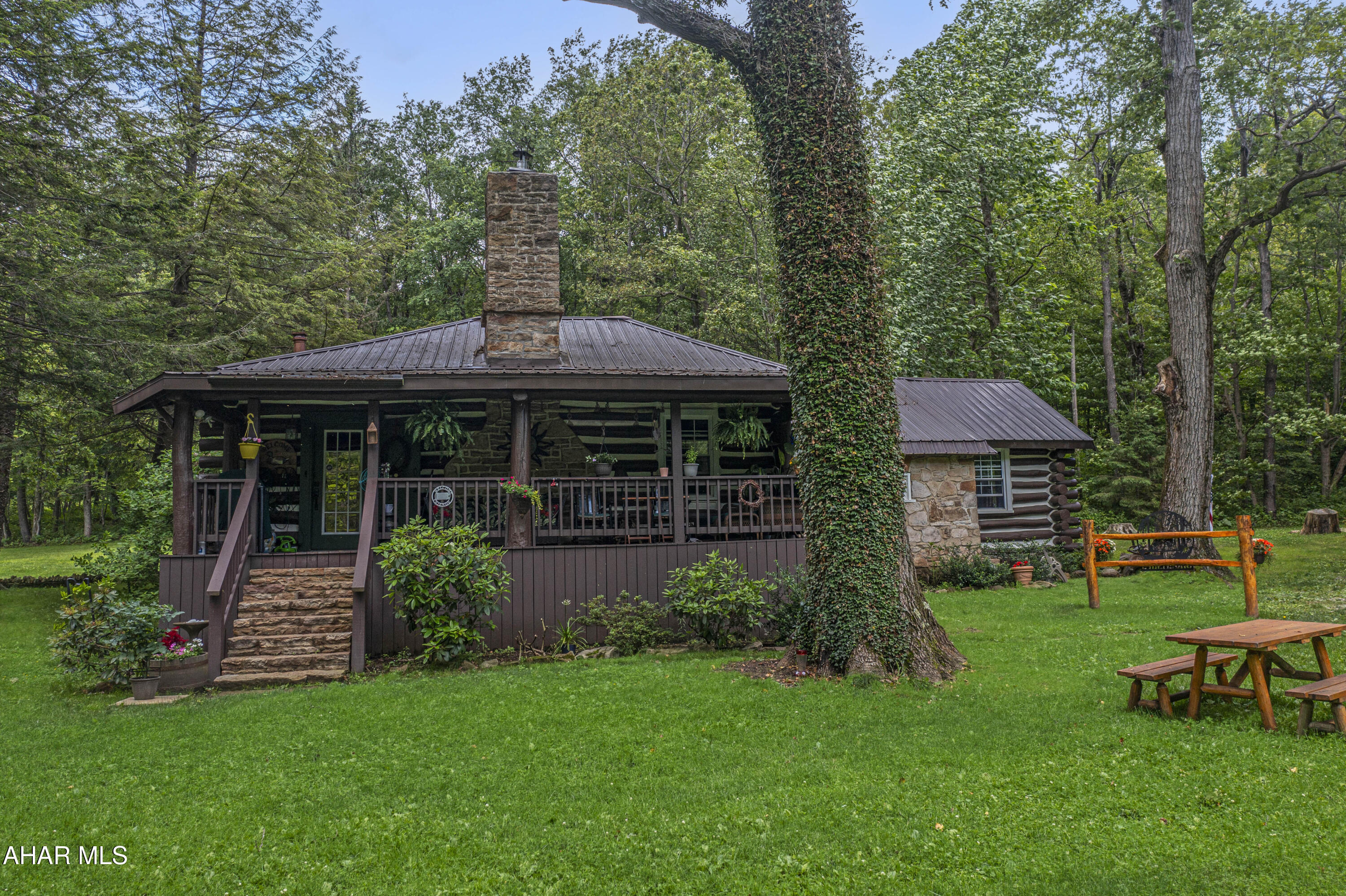 Discover a truly one-of-a-kind rustic log home tucked away in a secluded wooded setting just off Route 30. Believed to be well over 100 years old, this historic property has been beautifully preserved and thoughtfully updated, blending timeless charm with modern comfort. Inside, you'll find stunning hardwood floors, vaulted wood ceilings, and a massive stone fireplace in the living room that creates a warm, inviting atmosphere. Each bedroom features its own cozy stone fireplace, adding to the home's authentic character.

The kitchen and bathroom have been tastefully updated to offer modern convenience while maintaining the home's rustic appeal. Enjoy peaceful mornings and serene evenings on the covered front and back porches, or explore the property's 2.59 acres, complete with two ponds with a fountain, a stone spring house, and a storage shed.

Whether you're looking for a full-time residence or the perfect weekend escape, this property offers unmatched tranquility and charm. Located just minutes from Laurel Mountain Ski Resort, Seven Springs, the Quemahoning Reservoir, Jennerstown Speedway, and historic Ligonier. The home features both well and spring water sources, and an adjacent farm is also available for purchase. This is a rare opportunity to own a beautifully updated piece of rustic Pennsylvania history.
