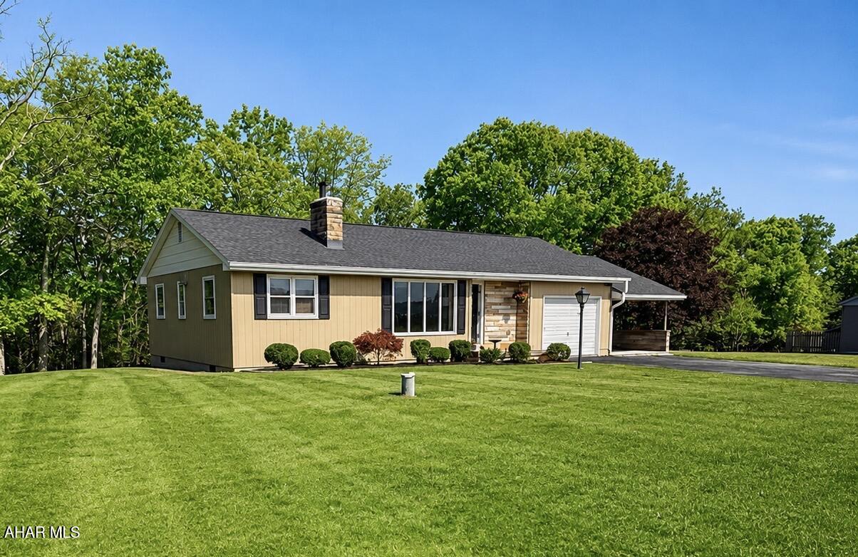 Nestled just outside of Everett on a quiet country road, this charming move-in ready home offers stunning mountain views, privacy, and a peaceful setting on approximately 2.1 acres. The wooded backyard acreage creates a beautiful natural backdrop and provides a wonderful private retreat, while the front yard offers stunning views of the Allegheny countryside landscape. The property extends down to the gravel road below, offering exceptional seclusion and a serene country setting.

Inside, the inviting living room features a stunning wall of casement windows and a beautiful stone fireplace with wood insert, creating the perfect space to relax and enjoy the scenery. The spacious kitchen offers excellent storage and opens directly to the rear deck through sliding patio doors, making indoor and outdoor living effortless.

The home includes one full bath, one half bath, and a lovely laundry room. Recent updates include newer flooring, newer roof, newer mini split units for efficient heating and cooling, updated paint and décor, and professionally improved crawlspace insulation and protection for added energy efficiency.

Additional features include an attached garage with potential for future living space conversion, a large carport, and an impressive 36x24 detached building ideal for a workshop, hobby space, vehicle storage, or small business use.

A rare combination of charm, comfort, and privacy in a beautiful country setting.