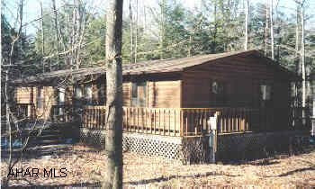 Nice log sided home with wood burning fireplace, wrap around deck. Very private- gated community.
