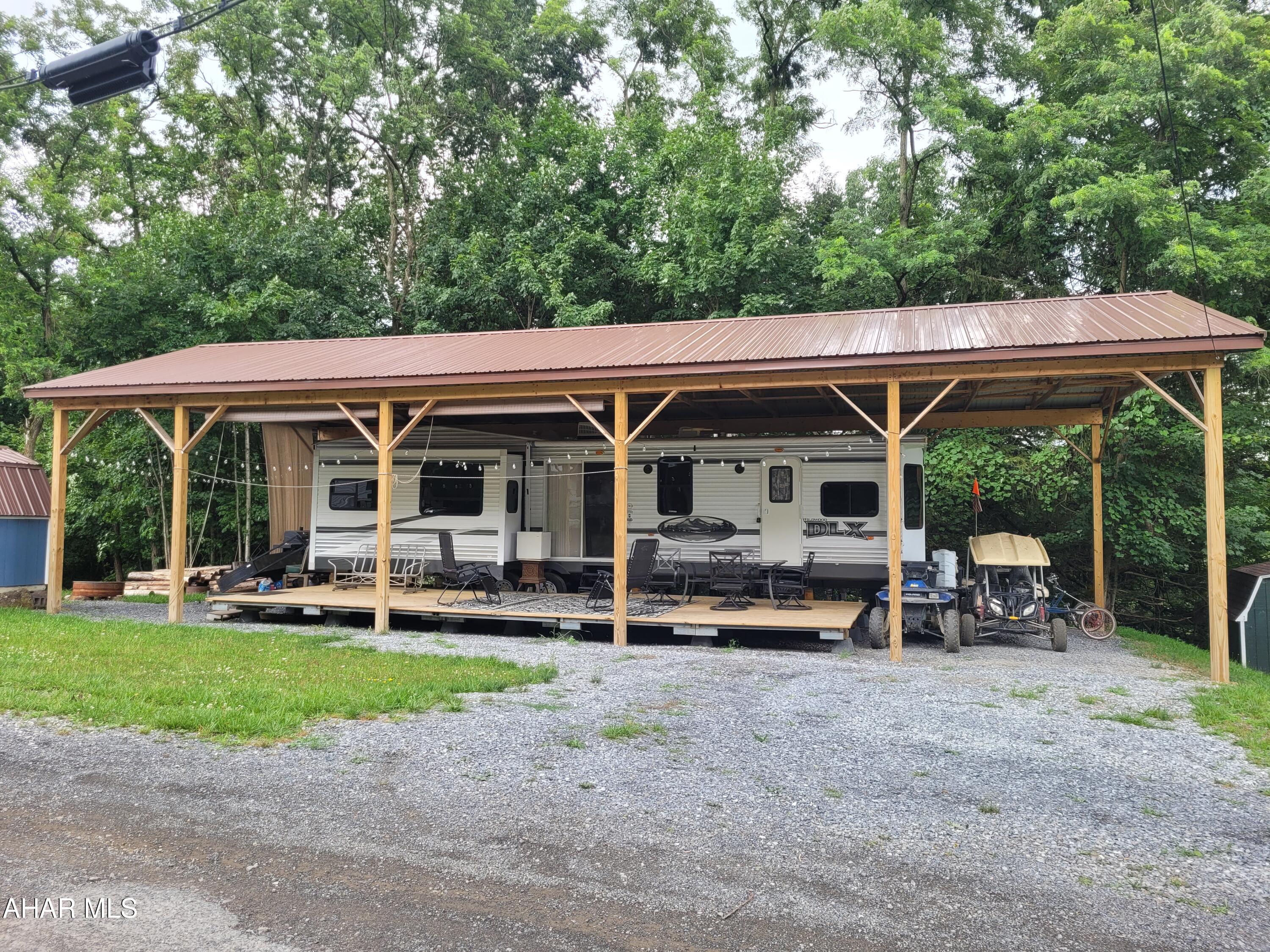 Glamping is in your future with this unit. Camping is about enjoying the great outdoors.  Relax on the covered deck, cook a hotdog or two over the fire and enjoy a jaunt on your golf cart or quad on your way to the pool.  
When evening comes - or the rain - get cozy inside in front of your fireplace while sharing time with family.  Watch a movie, play games or cook up a snack.  There is room in the living / kitchen area for all to participate.  At bedtime in addition to the spacious bedroom the loveseat offers additional sleep space. 
No more wondering what to do with your weekends or loading up the camper and hauling it down the road just to unhook it and set it up again.  You will always be up for a getaway.