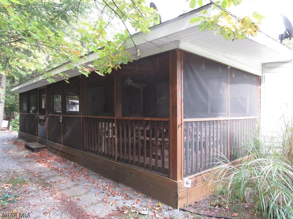 This park model is snuggled in to a private corner of Fernwood Circle surrounded by landscaping.  Not only is the bedroom roomy with lots of closet space, but the couch in the living room opens into a queen size bed.  Full bath accesses from the bedroom or hall.  Ample counter and cabinet space in the kitchen.  Sit at the table with windows on three sides to enjoy the view.  After all that the 11' deep full length screened in porch doubles your usable living space during camping season.  Private fire pit area and shed in the rear.  Sale includes furnishings, grill and golf cart.