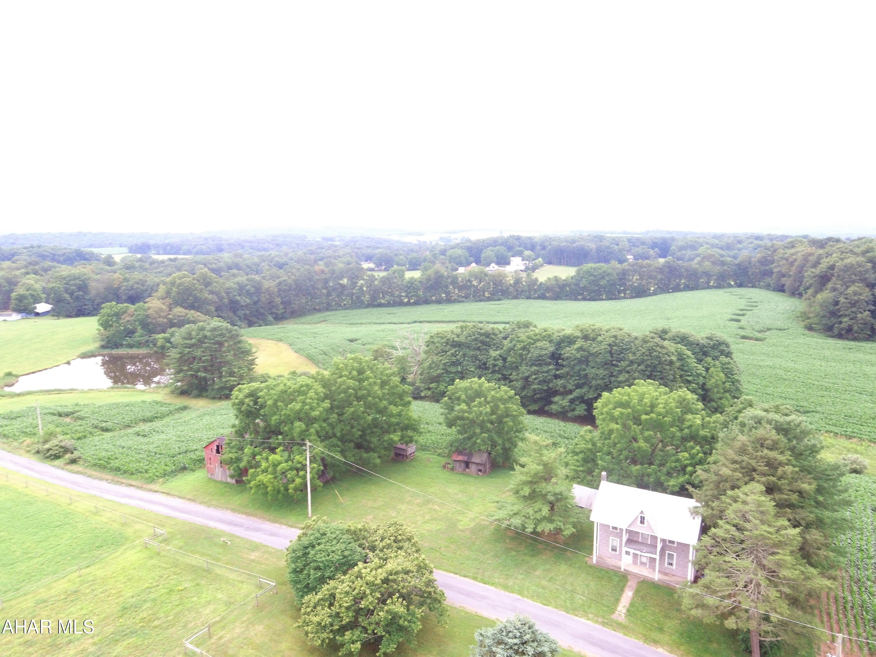 Two story farm house with multiple outbuildings resting on 28 +/- acres located in Fulton County, PA. The property consists of open and wooded land, large pond, and offers beautiful views of the countryside.