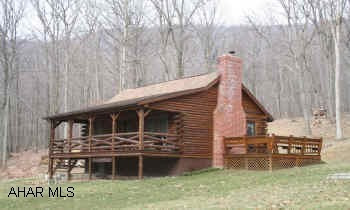 Log House ideal for second home; located on 4.505 acres, private wooded setting with the convenience of being close to town. Kitchen, DR/Great Room with high vaulted ceilings and cozy woodburner, BR & bonus room on main level; also has a loft bedroom. Large covered front porch, 12x12 side deck, garden shed.