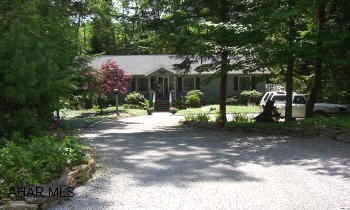 A beautiful home surrounded by lovely landscaping, screened porch in the back overlooks a small lake - great for fishing, wrap around deck with tons of storage underneath, 3 BR, 2.75 BA, beautiful stone FP in great room, & additional FP in FR, large kitchen with island & skylights.