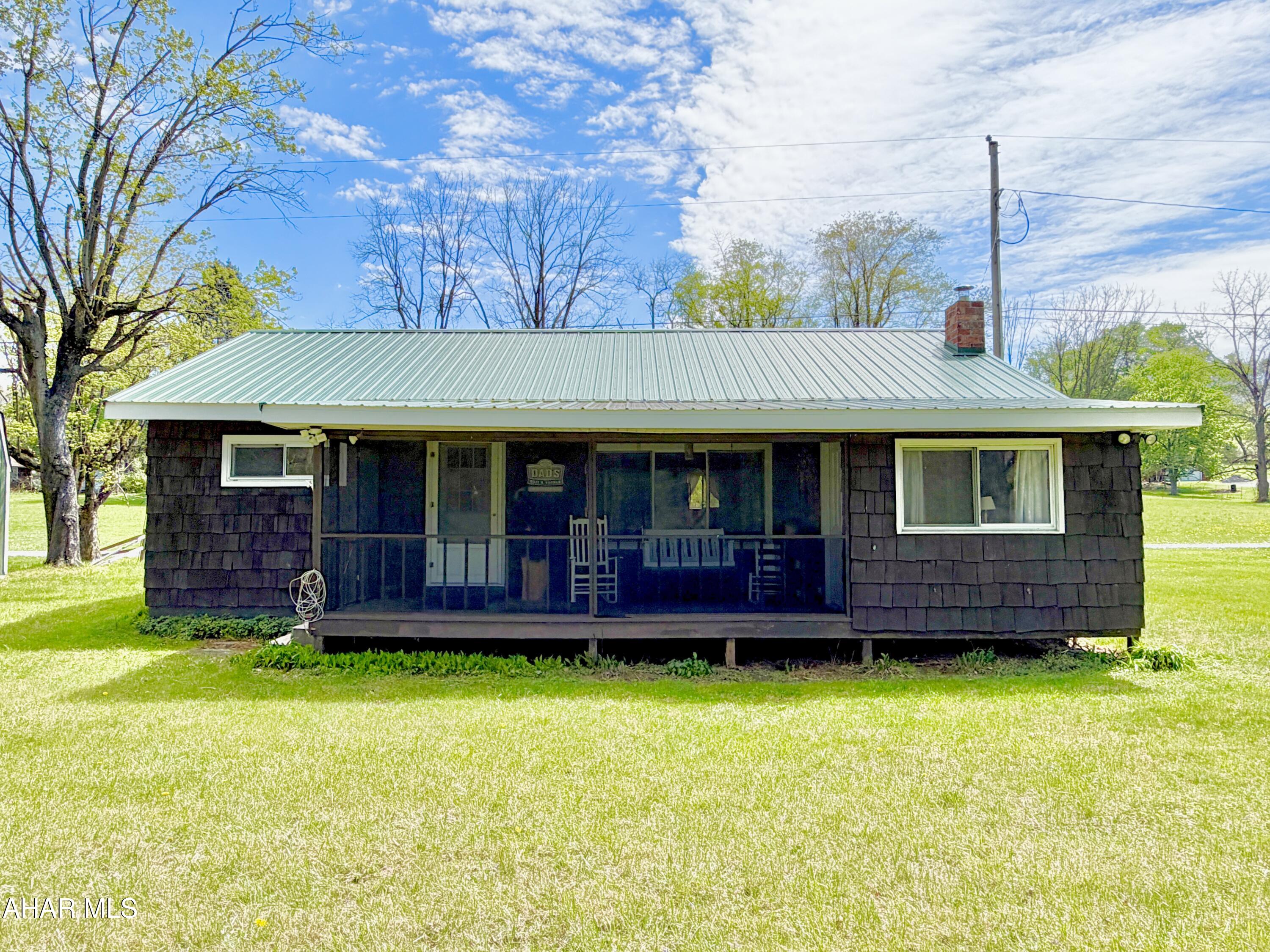 Hard to find cottage located along the Raystown Branch of the Juniata River! The cottage features three bedrooms, one bathroom, living room with brick fireplace, kitchen, dining area, and a bonus room. Outside, you'll find a spacious yard ideal for relaxing or entertaining, along with a covered screened porch and two storage sheds for added storage. Most interior furnishings, exterior items, and shed contents are included in the sale, offering a move-in-ready, turnkey opportunity for immediate enjoyment.