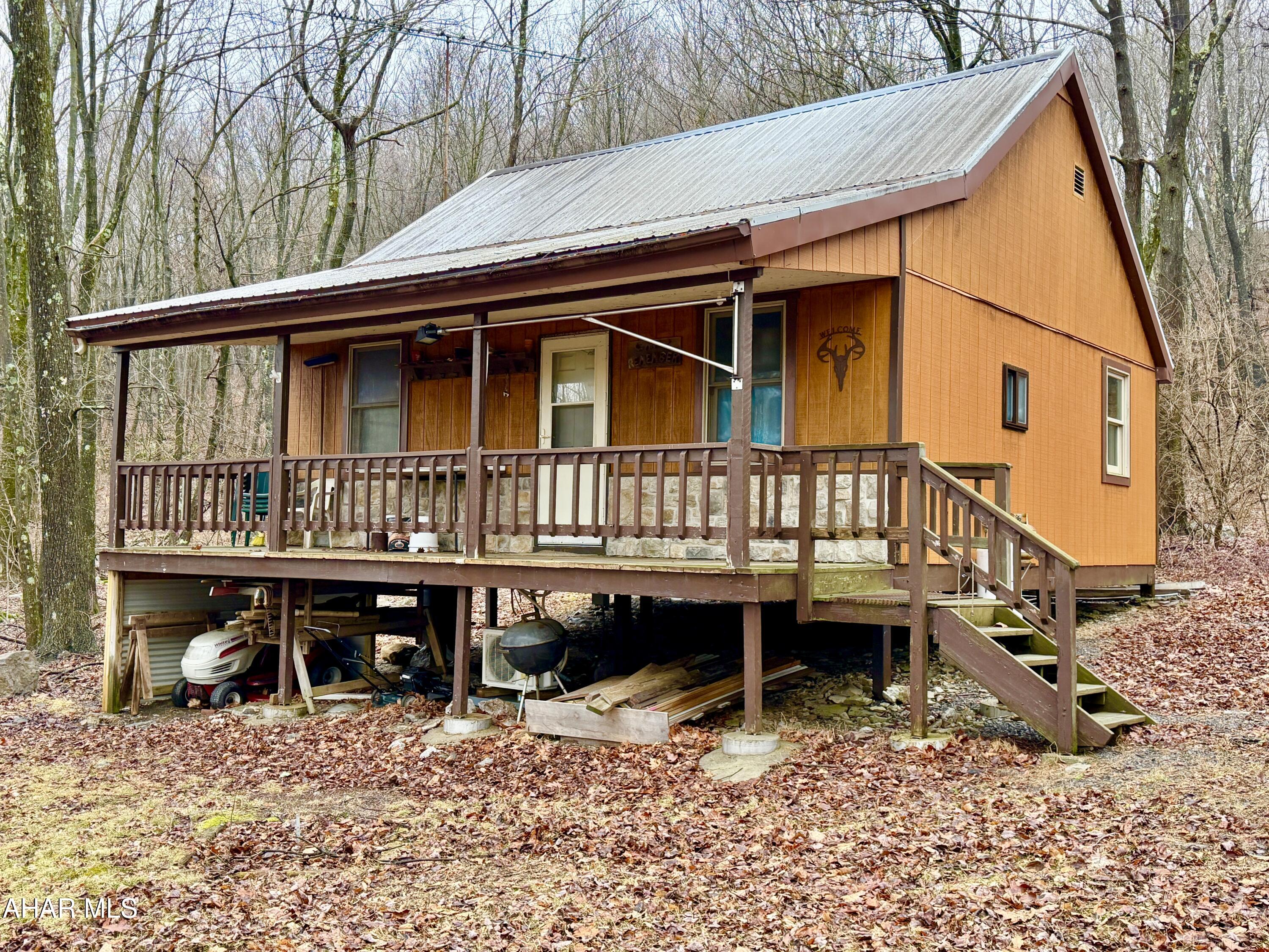 Escape to nature with this secluded cabin situated on 2.7± acres. The cabin features an open kitchen/living area and bunk room, ductless mini-split and propane gas wall heater, and a covered front porch perfect for relaxing and enjoying the outdoors. Located just minutes from Buchanan State Forest and the Pike 2 Bike Trail, the private setting offers the perfect escape while still providing easy access to the Pennsylvania Turnpike, Interstate 70, and U.S. Route 30. Property currently has no well or septic system.