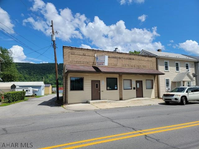 Two commercial offices with 40'  x 75' block garage/warehouse. One office is presently being used as a studio apartment. Other was previously used as an insurance office with reception area/office, 3 private offices, a kitchen, records room and a 1/2 bath. There are 2 gas forced air furnaces and 2 electric panels, but utilities are not separated. Large garage/warehouse has several room partitioned off in the rear, but could easily be opened back up. Off street parking.