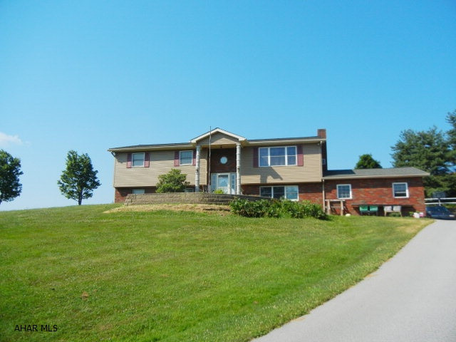 Logan Township bi-level, offers 4 BR, 2 BA, zoned HW heated home, with plastered walls & oak trim throughout.  On cold winter nights snuggle up next to the wood fireplace, set in natural stone, and listen to it crackle.  Entertain guests in the large, eat in kitchen, set up buffet tables in the spacious and bright 31 X 11 sunroom located conveniently just off the kitchen. (great place to set up buffet tables for large dinners) There is bonus room just off the master bedroom which is wired and plumbed for a hot tub-- could be an office, craft room, sitting room, or whatever you choose.   Enjoy wood working in the 30X40 workshop that is heated and has A/C.  The view is amazing - situated on approx 2.5 acres.  This home qualifies for rural housing-no money.