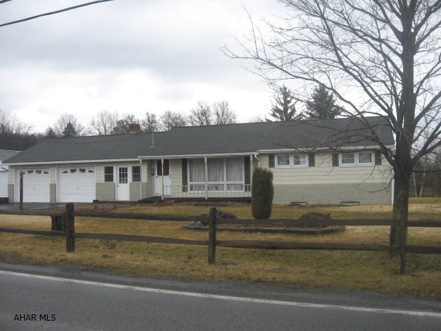 On one acre but close to town!  3 BR, 1 Bath, updated kitchen in 2000 with cherry cabinets and eat-in for 2. Dining area with a great back yard view - grass, mature trees, no neighbors.  10'x26' breezeway w/brick on part walls, propane stand-alone fireplace, big family room 31'x14' added for family get togethers. Covered front porch, split rail fence, edged flower beds - great country look!  This home needs some updating - flooring, front door area, shower unit - but can be a great family home on an acre of ground! Shed at back. Full basement unfinished with room to spread out or use as storage.  Two car garage that's 25' deep and has room for storage, too. Lots of room to spread out - inside and out!  Worth taking a look!