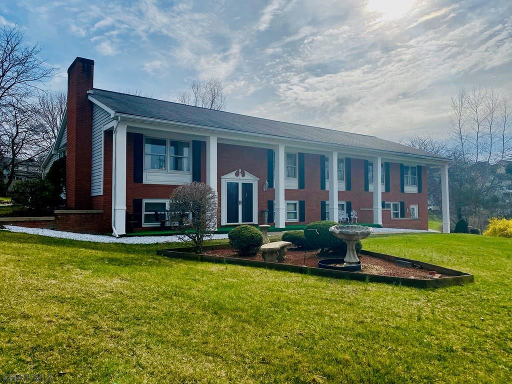 You are going to LOVE what this spacious brick has to offer you! How about an open floor plan, updated kitchen, 3 season room, hardwood floors in kitchen and dining room? Not enough.....HUGE master suite with more space than you'll know what to do with 4 closets and a walk in shower with bench! 2nd bedroom has it's own bathroom and double closets, 2 more bedroom, and walk up attic storage. 2 finished family rooms in the lower level one cozy with a fireplace and the other with ceramic tile floors all ready for your pool table and bar! Nice big 2 car garage, 1/2 acre corner lot, big patio right off of the 3 season room,  plenty of curb appeal, & a 1/2 bath in lower level! All it is needs is your style and YOU. 1 year home warranty included.