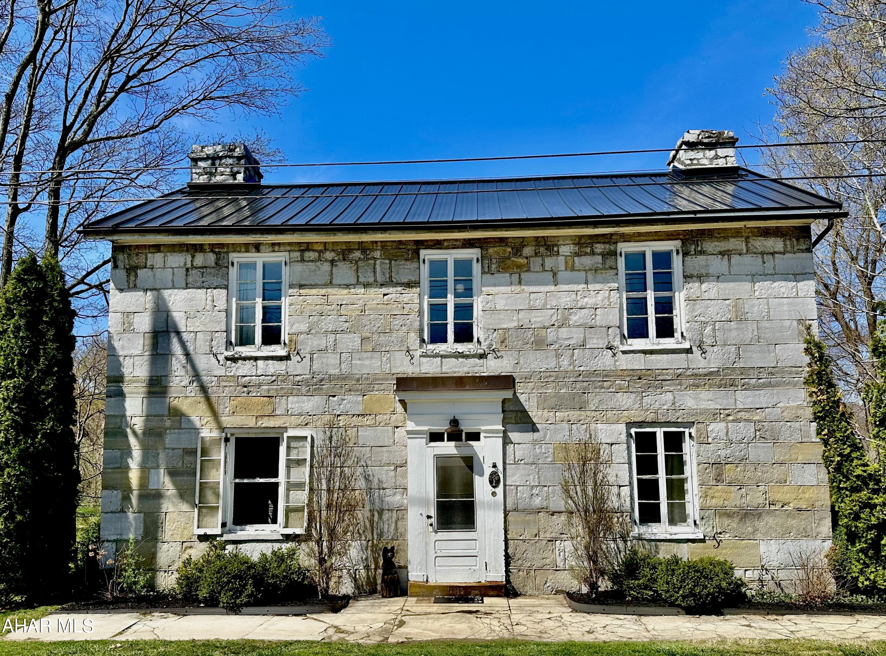 A rare opportunity to own a piece of history with this wonderful circa 1849 cut limestone home in Bedford County, PA.   Nestled on just over 7 flat acres with gorgeous mountain views and a small winding stream. There is plenty to do for the outdoor enthusiast, with two covered porches, raised beds, and several fruit trees including pear, gala and yellow delicious apple.   Inside the home much of the original charm remains with deep window sills, exposed stone accents, built-ins and original wood floors.   Three bedrooms plus a captive nursery on the second floor and a full bath on each floor.  New standing seam metal roof, fully rewired with 200 amp service, main level laundry and much more.   Give us a call today to make this wonderful home yours!