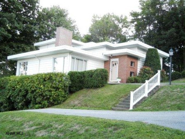 Frank Loyd Wright inspired, mountain views from every room, multiple driveways, hardwood under carpet, covered patio used as carport in winter, storage abound.  Almost 1/2 acre. Commercial rubber roof in 2001. Newer windows,furnace, AC, hot water heater & electric. Owner is a licensed Realtor.