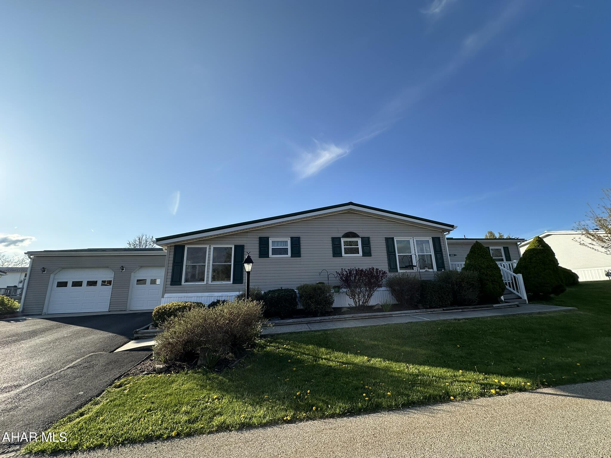 Beautiful spacious home on rented lot in the picturesque community of Sunny Acres. This manufactured home features a large eat-in kitchen with pantry, laundry room, formal dining area with open concept layout overlooking a living room and bonus family room. Three total bedrooms with primary bedroom featuring his and her closets and en suite bath. One additional full bath. Sun room leads into the two car attached garage with bonus storage area. Lovely porch with Trex decking overlooks a meticulously landscaped flower garden. Just the right amount of yard. Natural gas heat and central air. Lot rent includes sewer bill, trash removal and snow removal. Sunny Acres community is in a prime location close to all amenities. The community itself features a pond, playground, basketball court, 24 hour maintenance and on-site management. Don't miss this opportunity to take part in all this property has to offer!