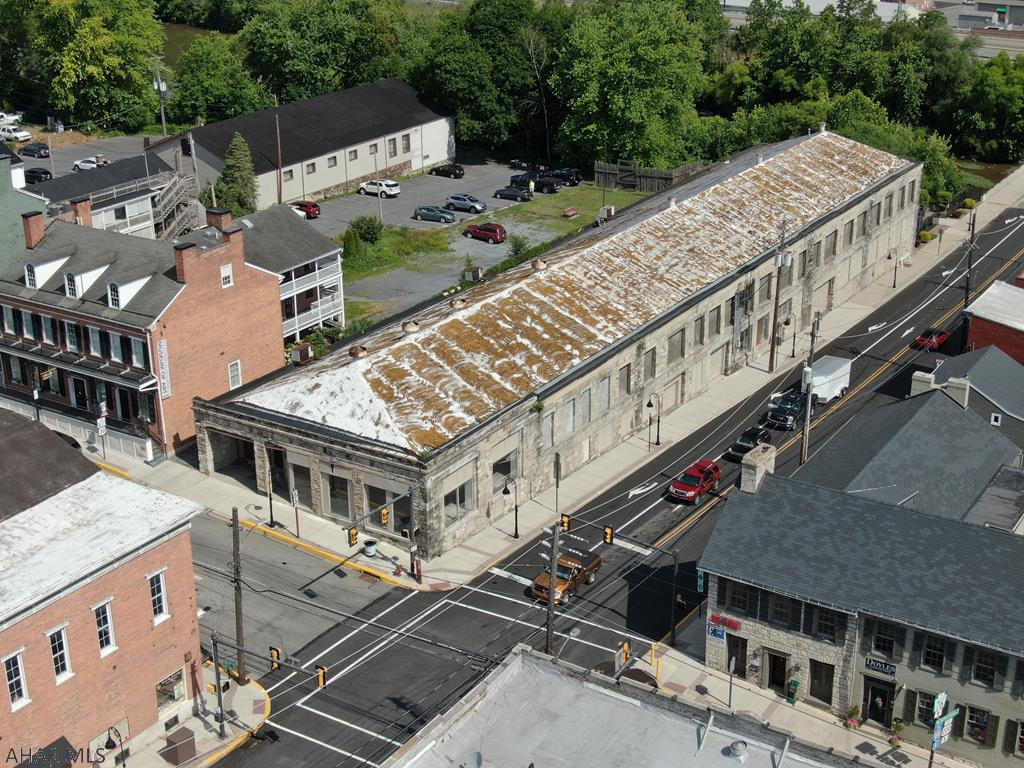 Commanding, one of a kind, stone building located at the busiest corner in the Bedford Borough. Originally built as a Ford Dealership in the early 1900's, this property presents endless possibilities and opportunities. Light manufacturing, warehousing, retail, office space, housing, parking garage, mixed use, etc. Building contains approximately 34,500 square feet, is all masonry and steel construction and free span on the main level. Lot size is .41 acre with city water, sewer and natural gas. Situated in the heart of storied downtown Bedford, next to the Southern Alleghenies Museum of Art, the original Fort Bedford and just steps to the Raystown Branch of the Juniata River. This is a rare opportunity to own one of Bedford's most prominent buildings!!!