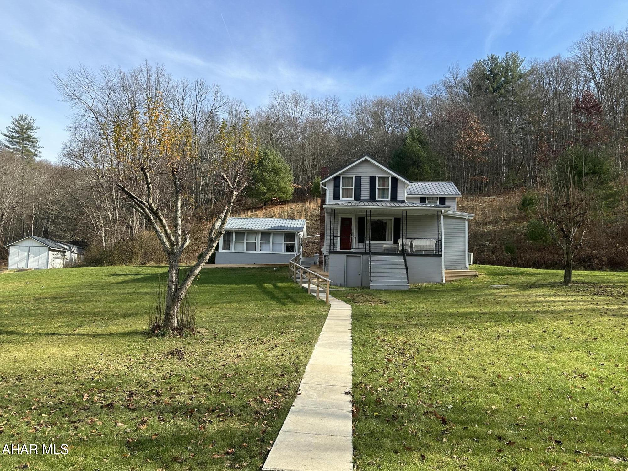 This is a charming two-story home with a traditional design located in a rural setting that is partially wooded. This home exudes a peaceful & rustic vibe, perfect for a quiet countryside lifestyle. The kitchen offers ample cabinets, beautiful granite counters and appliances included. Large living room with natural sunlight.  First floor laundry and a full bath with a step in tile shower. A separate sunroom for summer & fall evenings. Two car detached garage and a two car carport for ample parking.  A metal roof adds a durable and modern touch to the property. Two additional sheds for more storage.  Central air. Sellers are in the process of cleaning the contents of the home out....