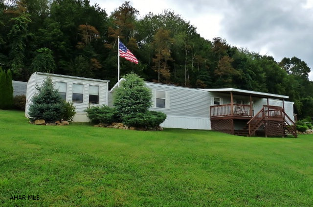 1997 3BR, 1BA singlewide with additions: covered porch to enjoy the scenic views of the mountains, covered rear porch, enclosed back porch and a hobby room. The home is serviced by public water/sewer and includes central A/C, washer/dryer, kitchen appliances, ceiling fans and 2 sheds.