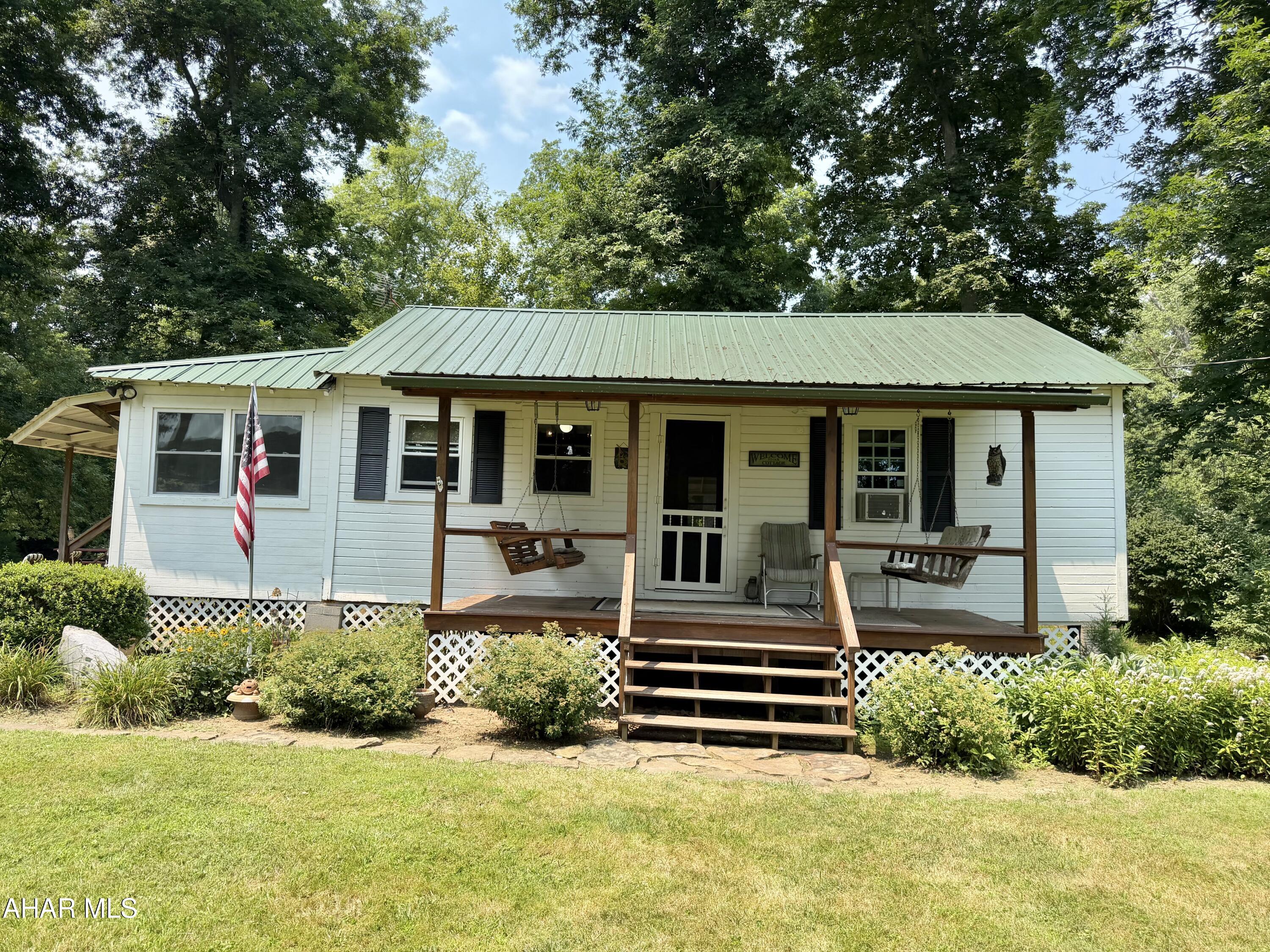 THIS IS YOUR OWN LITTLE SLICE OF PARADISE YOU'VE BEEN SEARCHING FOR!!  This picturesque cabin on the creek can now be YOURS! Dunnings Creek is literally in your back lawn.  3 Bedroom, 1.5 bath Very well maintained get away sits on a flat lot containing slightly over one half acre. This is serenity at its finest! Extra-large cozy wraparound porch allows you to enjoy summer evenings with screens in the windows. Or, when the weather gets chilly, simply close those windows and continue enjoying the view over Dunnings Creek. There's even a dock to drop your kayak into the water for a leisurely float down the creek.  Sizeable front lawn allows for plenty of space for entertaining. Toast your marshmallows over the fire ring. Rustic decor lends so much charm to this cottage/cabin.  You'll love the loft as well. There is a storage shed with attached carport also enhancing the property.  You truly have to see this for yourself to see all it offers. This one won't last long!  Call today for your personal showing.  This is getaway spot you've been dreaming about!