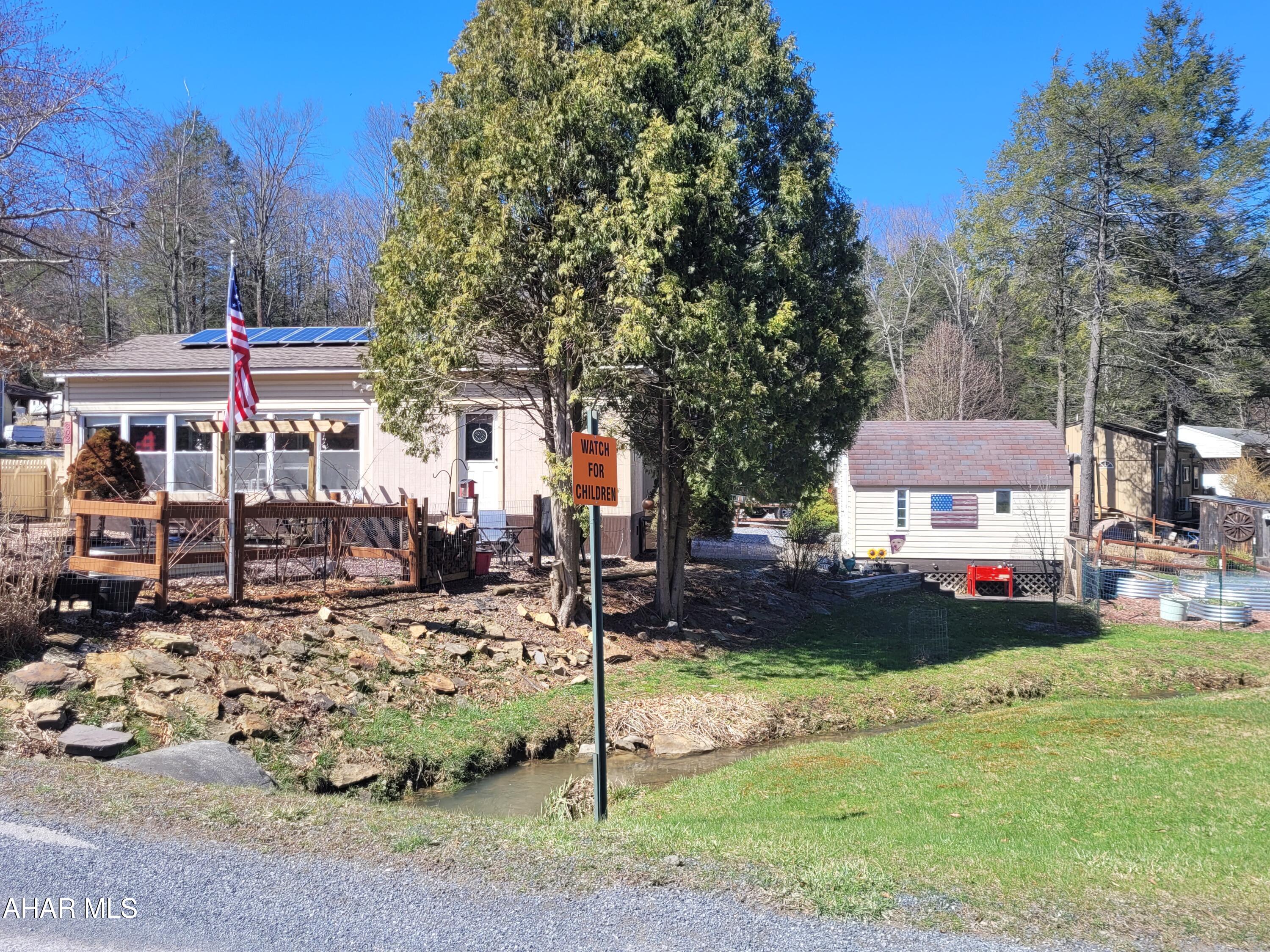 Sometimes down sizing isn't just about the square footage.  It's about a home that reduces your utility and tax costs; and growing some of your own food by making the most of the land.  
302 Fox Ridge Lane is a one level home that has been renovated to keep you snug and warm in the winter and cool in the summer while watching nature from your sunroom or enjoying the fruits (literally) of your labor.  
The floors have extra insulation as well as heat  underneath to keep them warm and your pipes safe from freezing.  With a pellet stove for winter and air conditioning for those hot days you will always be comfortable.  The solar system provides a minimal electric bill and ensures you will have electricity even when the power is out.  
The appliances and water heater are newer to give you peace of mind.  
Do you need room to sleep a crowd?  There is space in the sunroom for a sofa bed, bunks and / or a futon.  Come and be impressed.